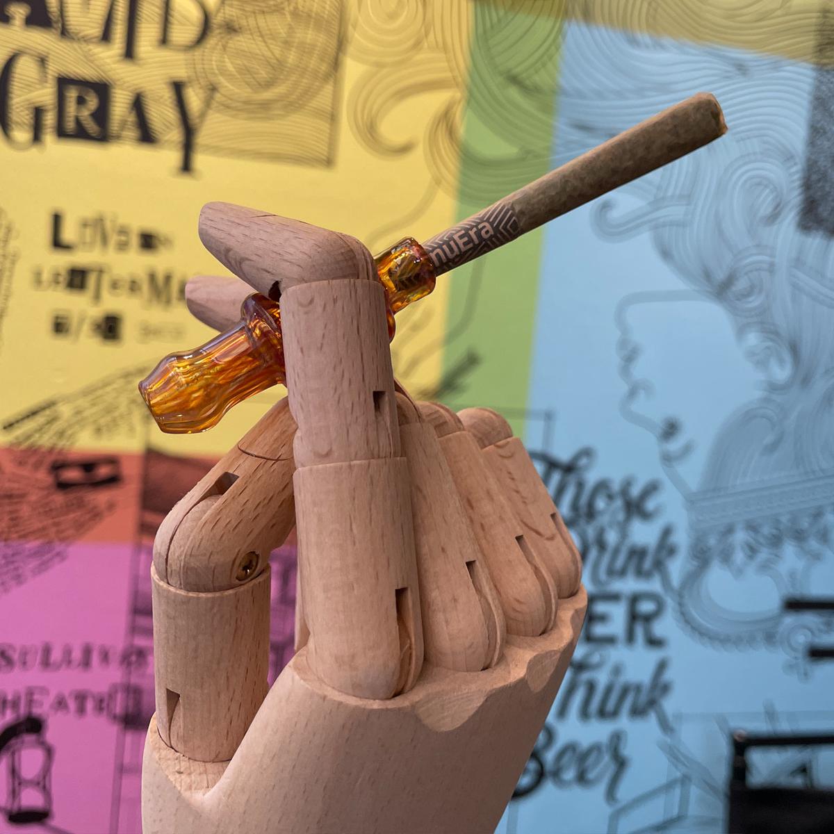 Wooden hand holding a nuEra Dubble Joint glass holder