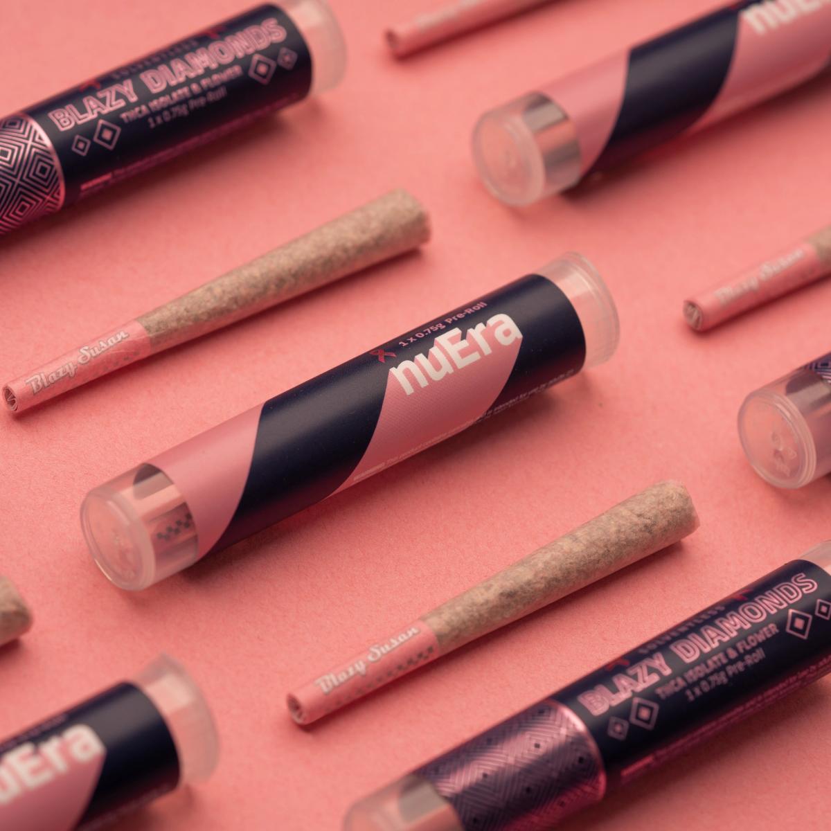 nuEra and Blazy Diamonds pre-roll tubes scattered on pink