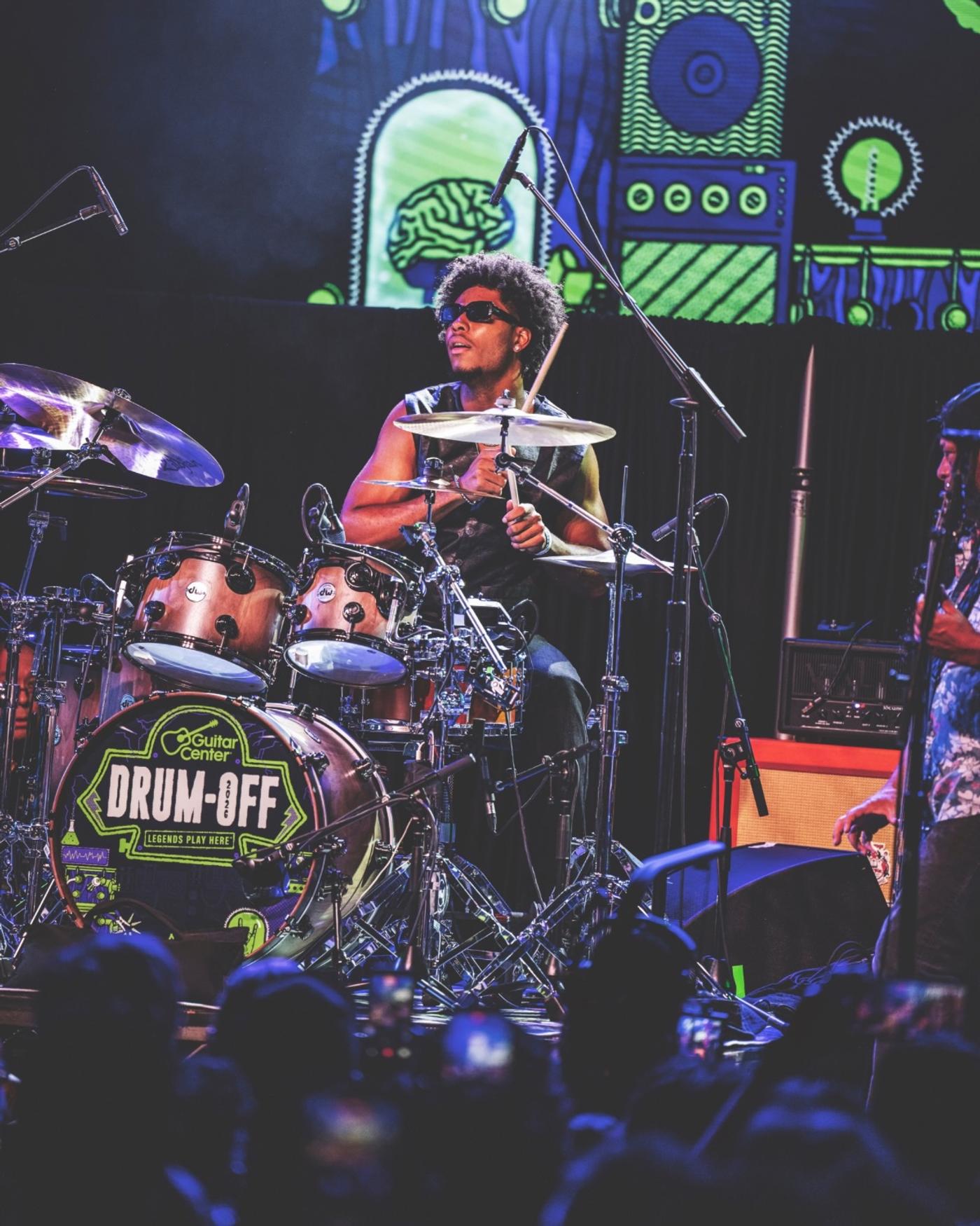 A drummer playing a kit with a Drum-Off kick drum head