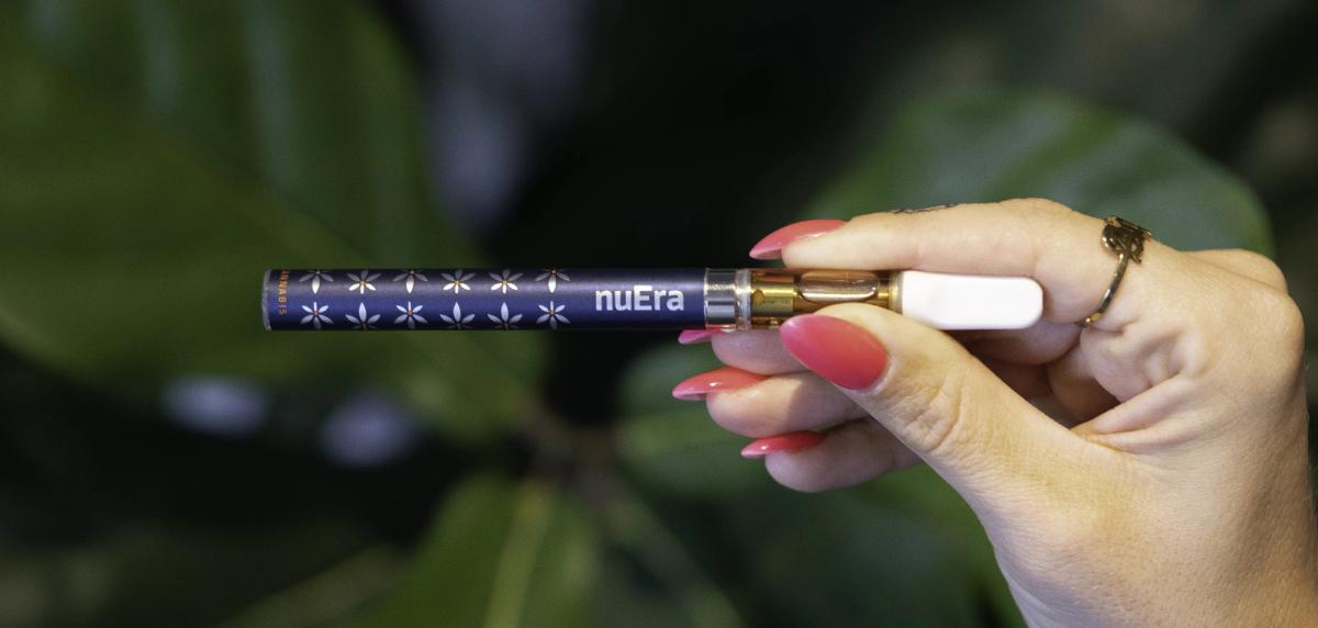 Hand holding a navy nuEra vape battery