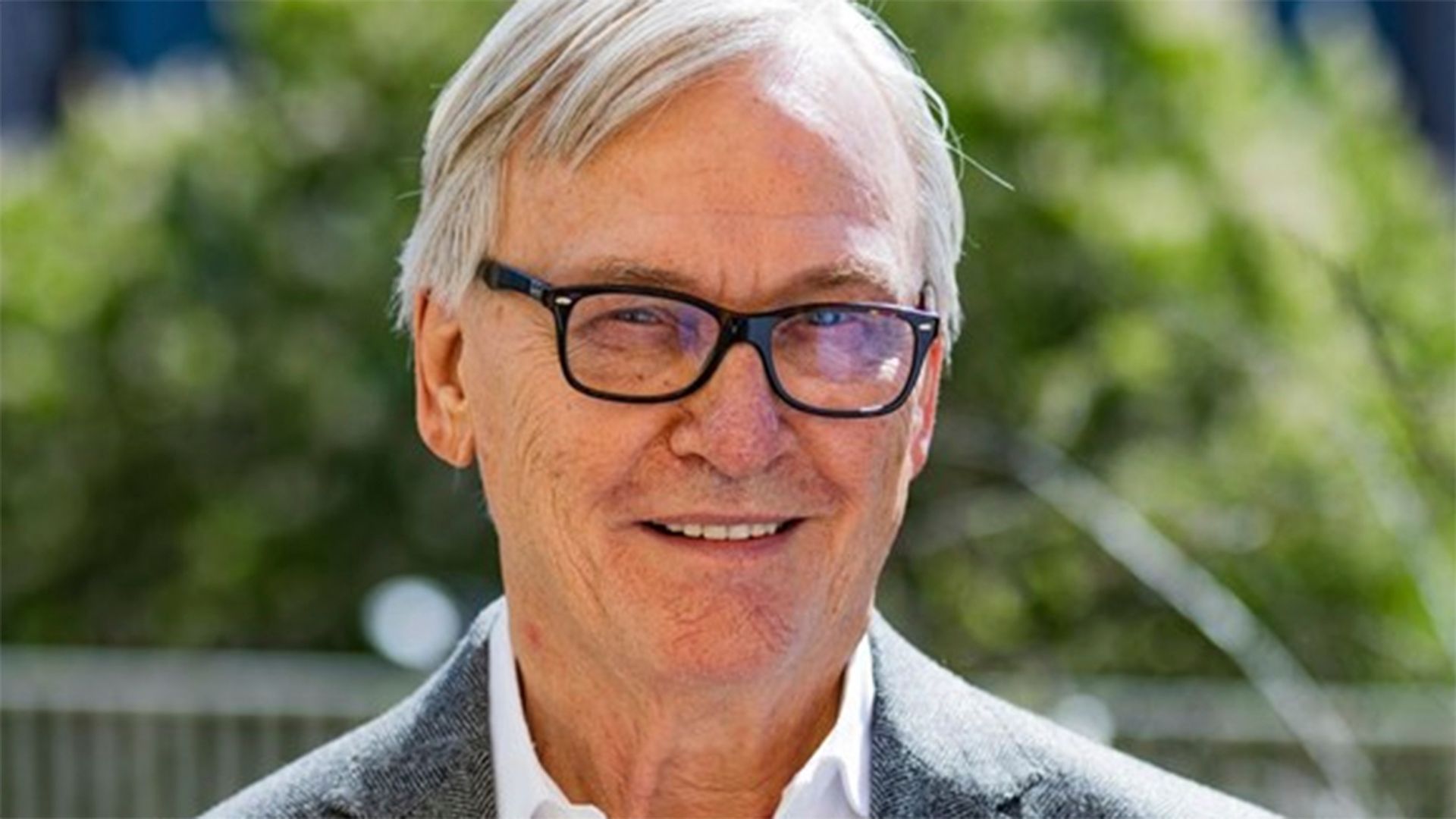 Porträtt på Klas Bergling som står i soligt väder med grönska i bakgrunden.