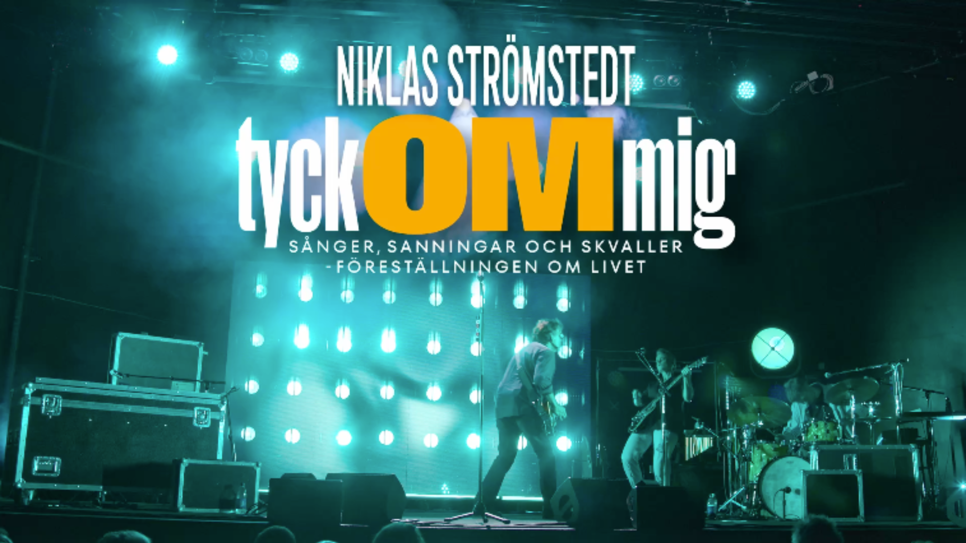 Niklas Strömstedt uppträder med band på en scen i blågrönt ljus. Text: ”Niklas Strömstedt – Tyck OM mig. Sånger, sanningar och skvaller – föreställningen om livet.” Spelas på China Teatern i Stockholm den 9 december 2026.