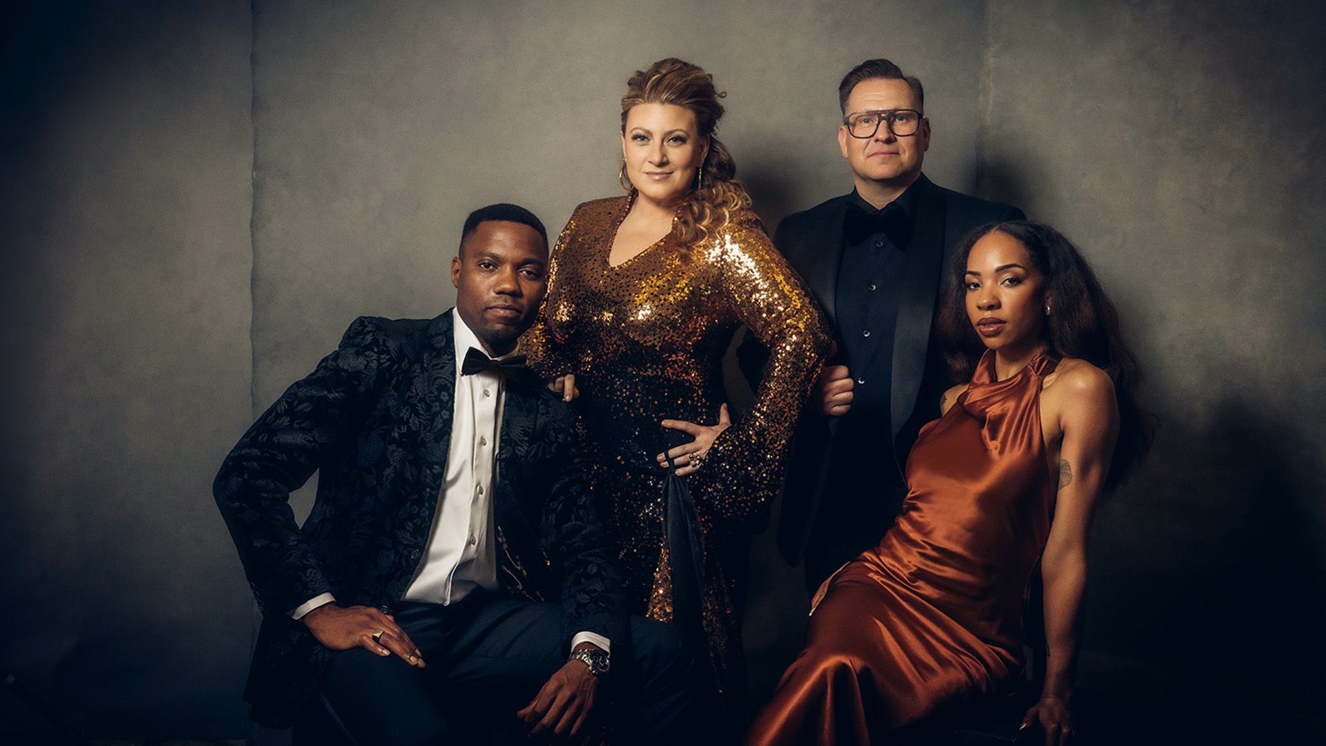 Pressbild för The Soul of Christmas med Prince Prime, Sarah Dawn Finer, Samuel Ljungblahd och Janice. De poserar i eleganta festkläder i svart, guld och koppar mot en mörkgrå bakgrund. Julturnén spelas 2–13 december.