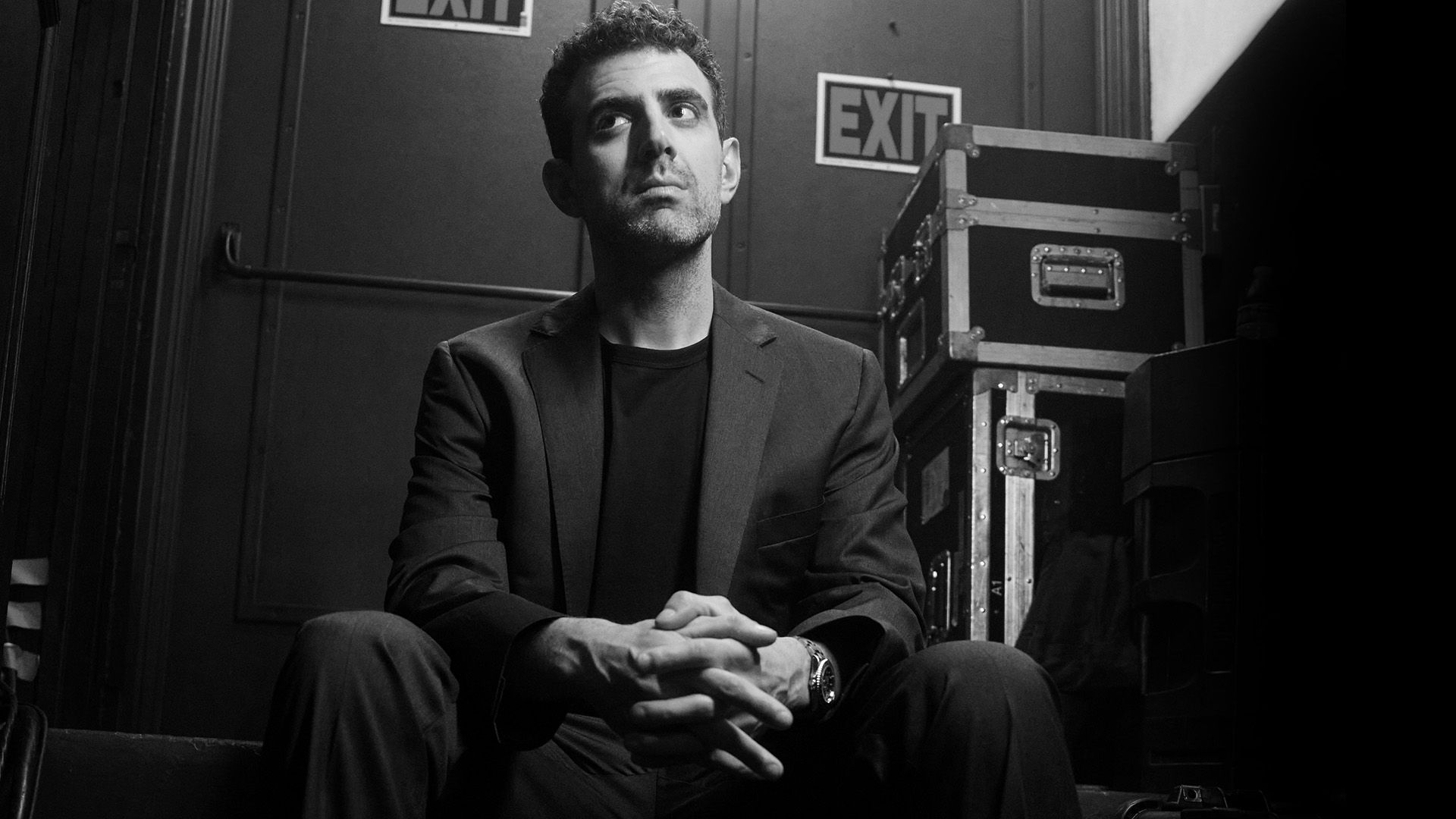 Sam Morril standup show –  bakom scen med EXIT-skyltar, porträtt inför liveföreställning