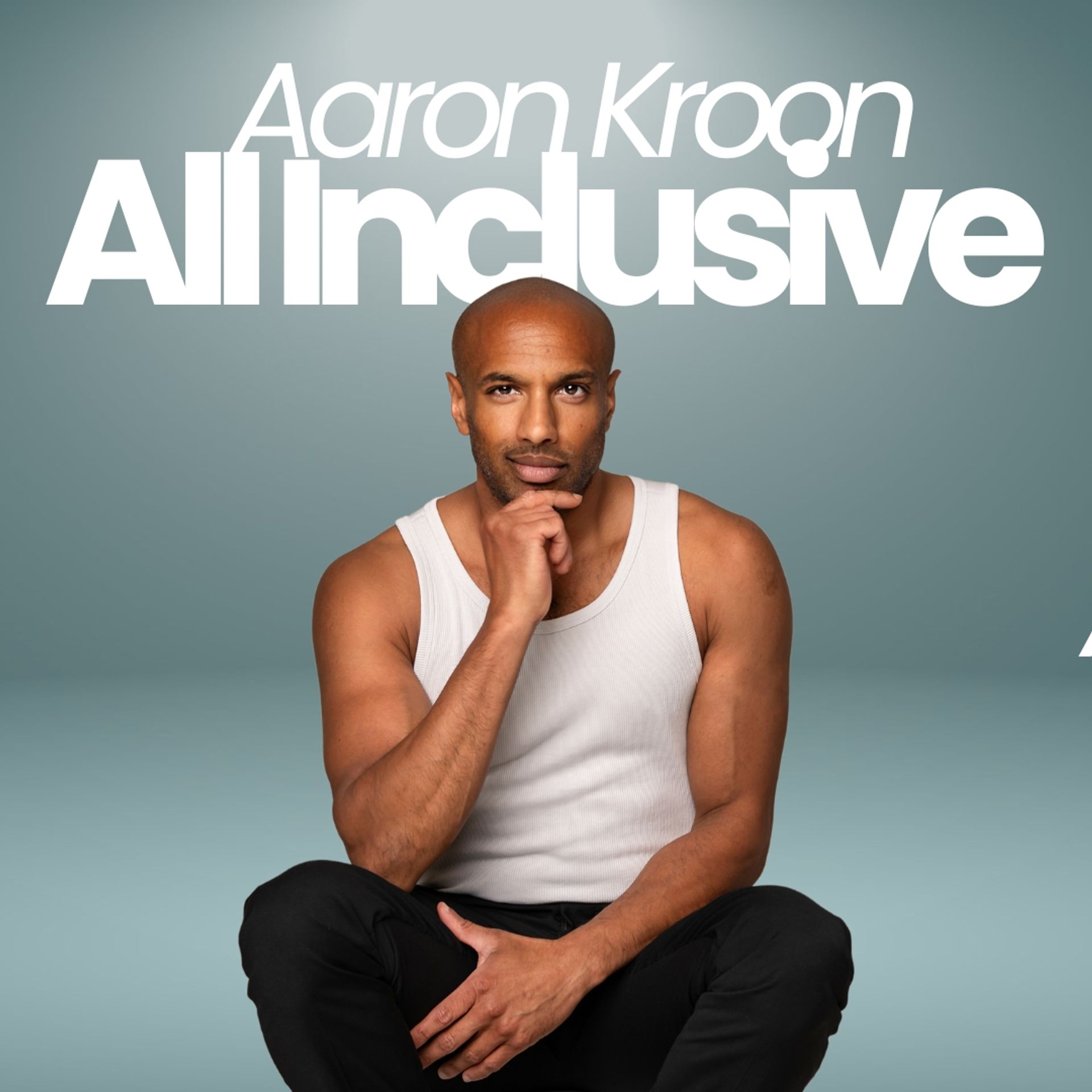 Aaron Kroons show All inclusive. Aaron sitter på golvet och håller handen på hakan och ser funderande ut.