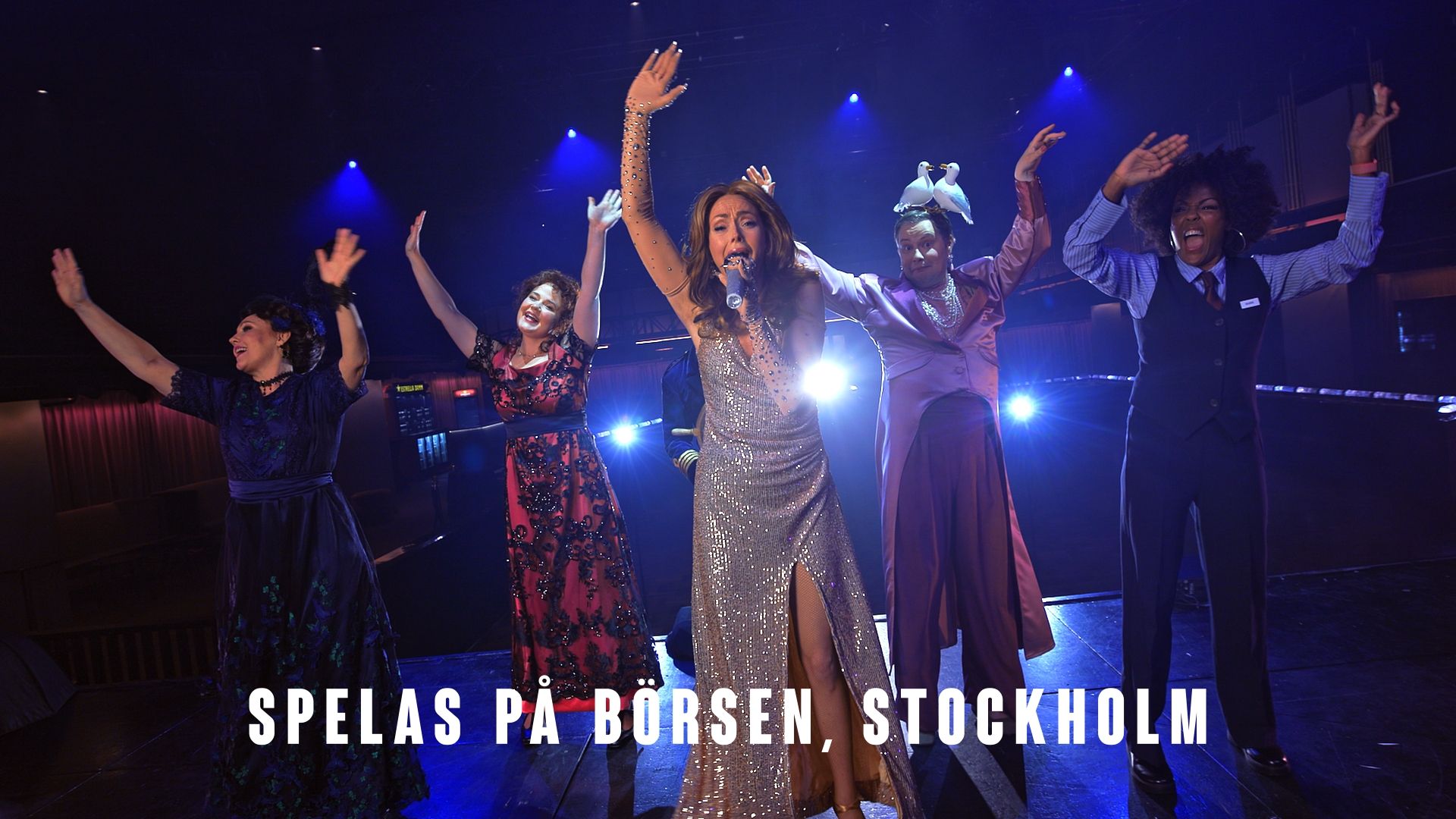 Scenbild från Titanique på Börsen i Stockholm. Linda Ohlsson står i mitten i en glittrande silverklänning och sjunger i mikrofon, omgiven av fyra personer med armarna i luften under blått scenljus. Text i bilden: ”Spelas på Börsen, Stockholm”.