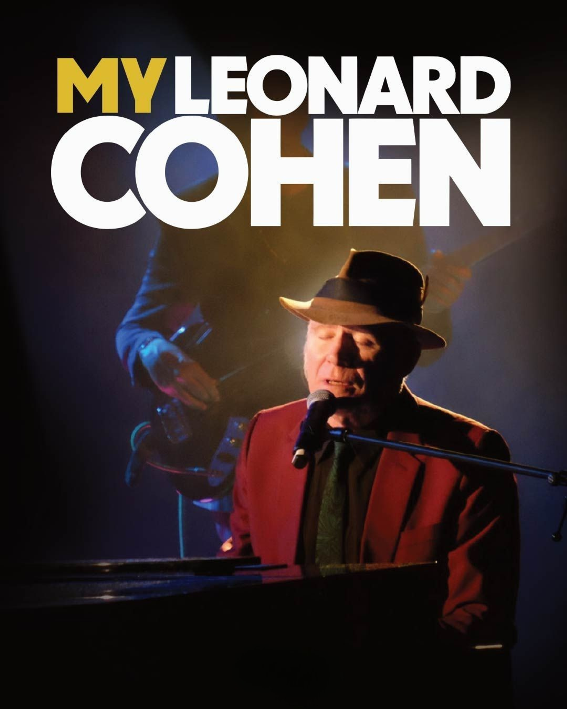 Manér bild för konserten My Leonard Cohen som föreställer Stewart D'Arrietta när han sitter och sjunger vid ett piano under en strålkastare.