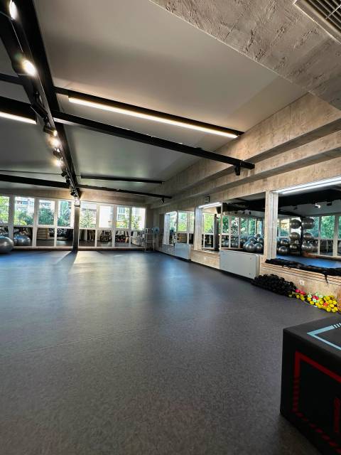A group-class hall with a rubber floor, mirrors and fitness balls
