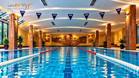 The indoor pool with blue lane ropes, Zoggs bunting and wooden columns