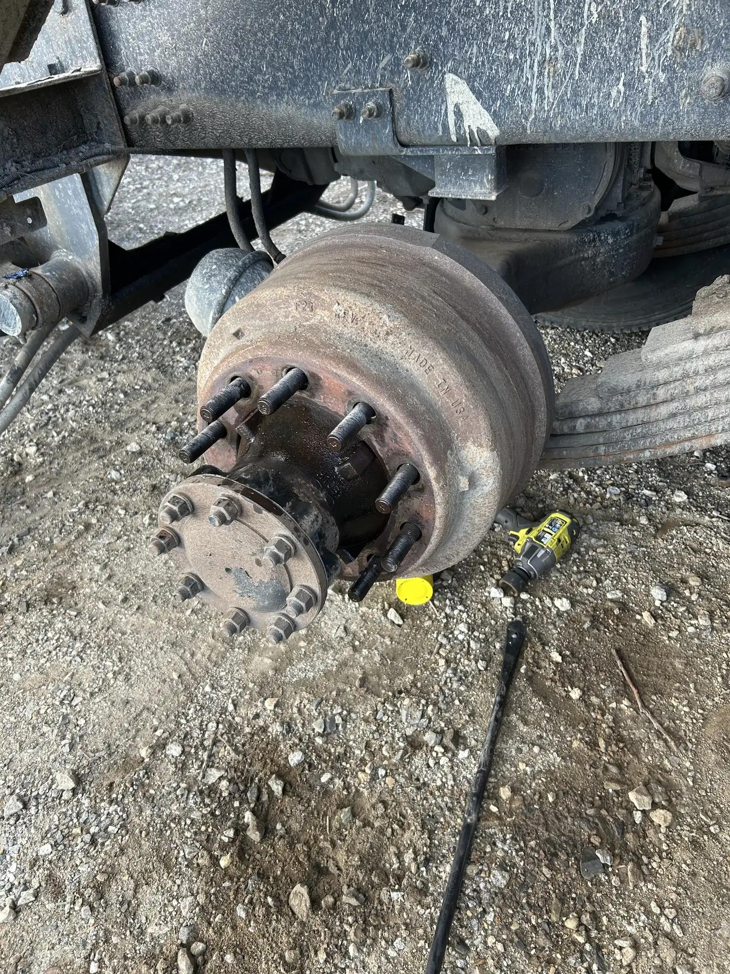 Trailer hub and drum on the ground during roadside wheel-end work