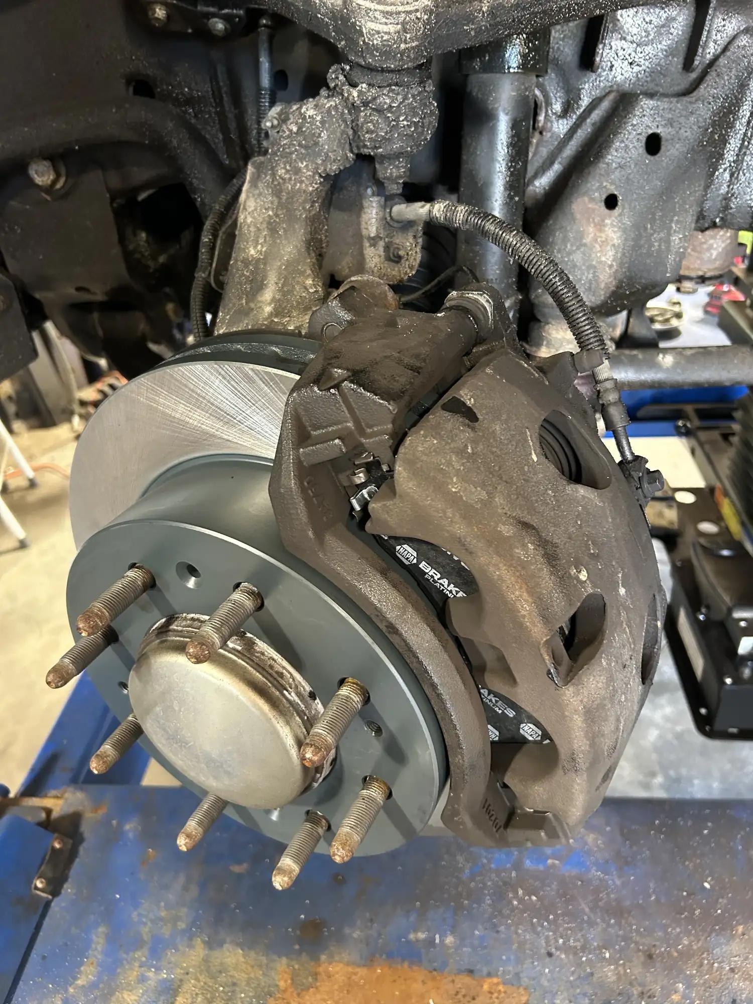 New brake rotor and caliper installed on a truck front axle