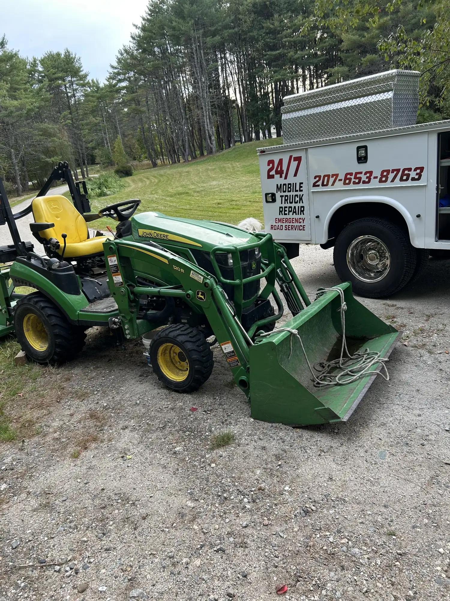 Compact tractor with loader next to the 24/7 mobile repair truck