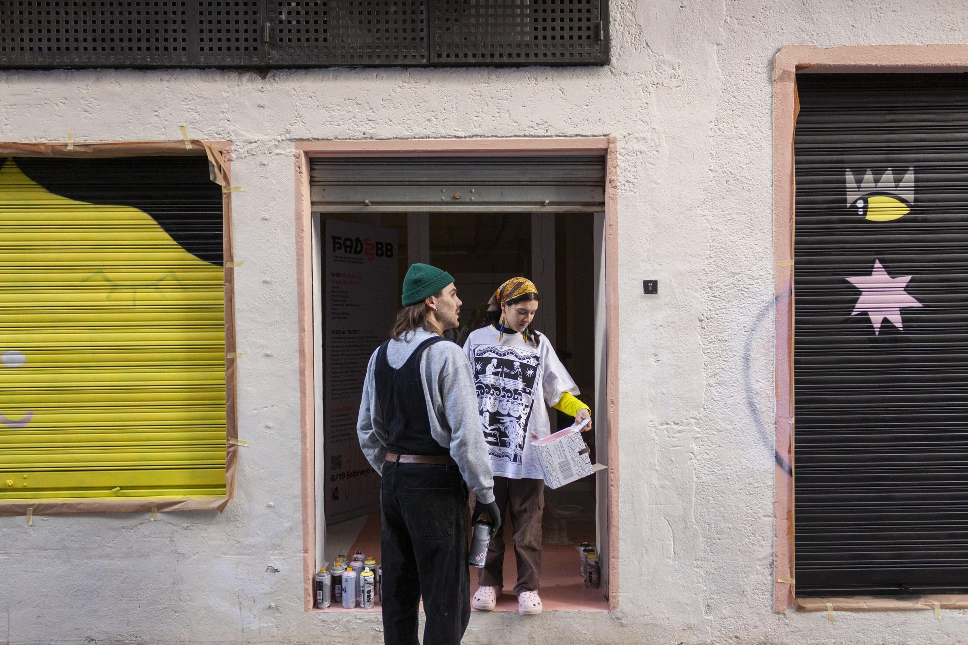Artists beside painted shop shutters in Boquerón