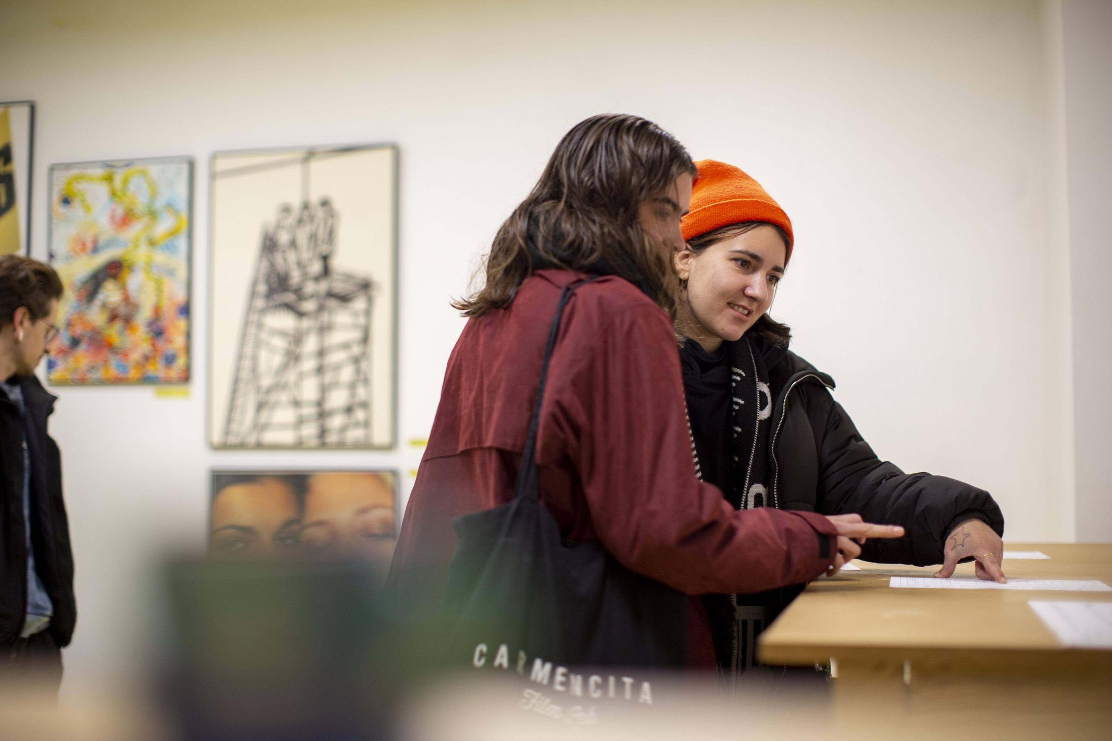 Visitors talking in front of the exhibition artworks
