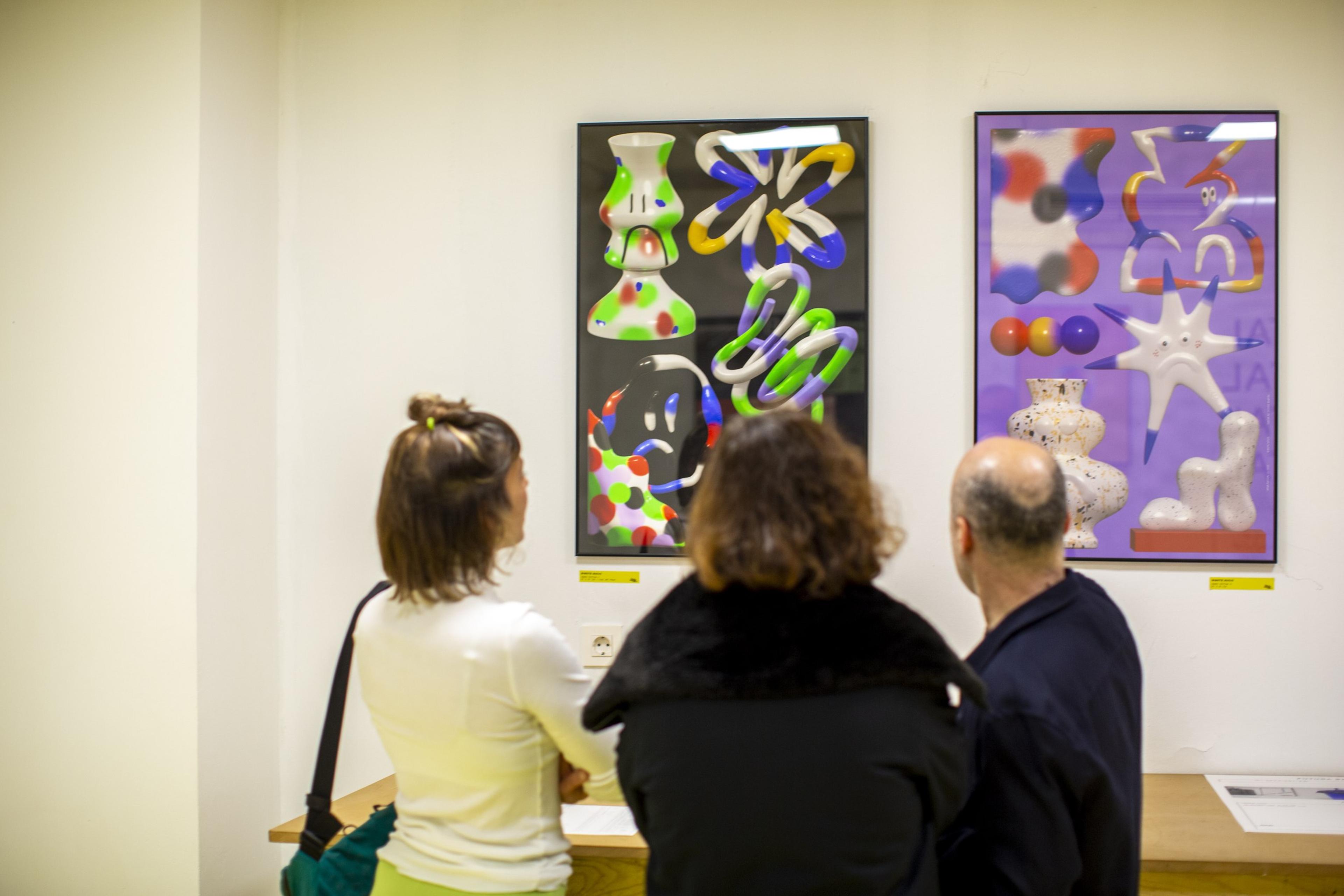 Visitors viewing two graphic artworks at Maneiras