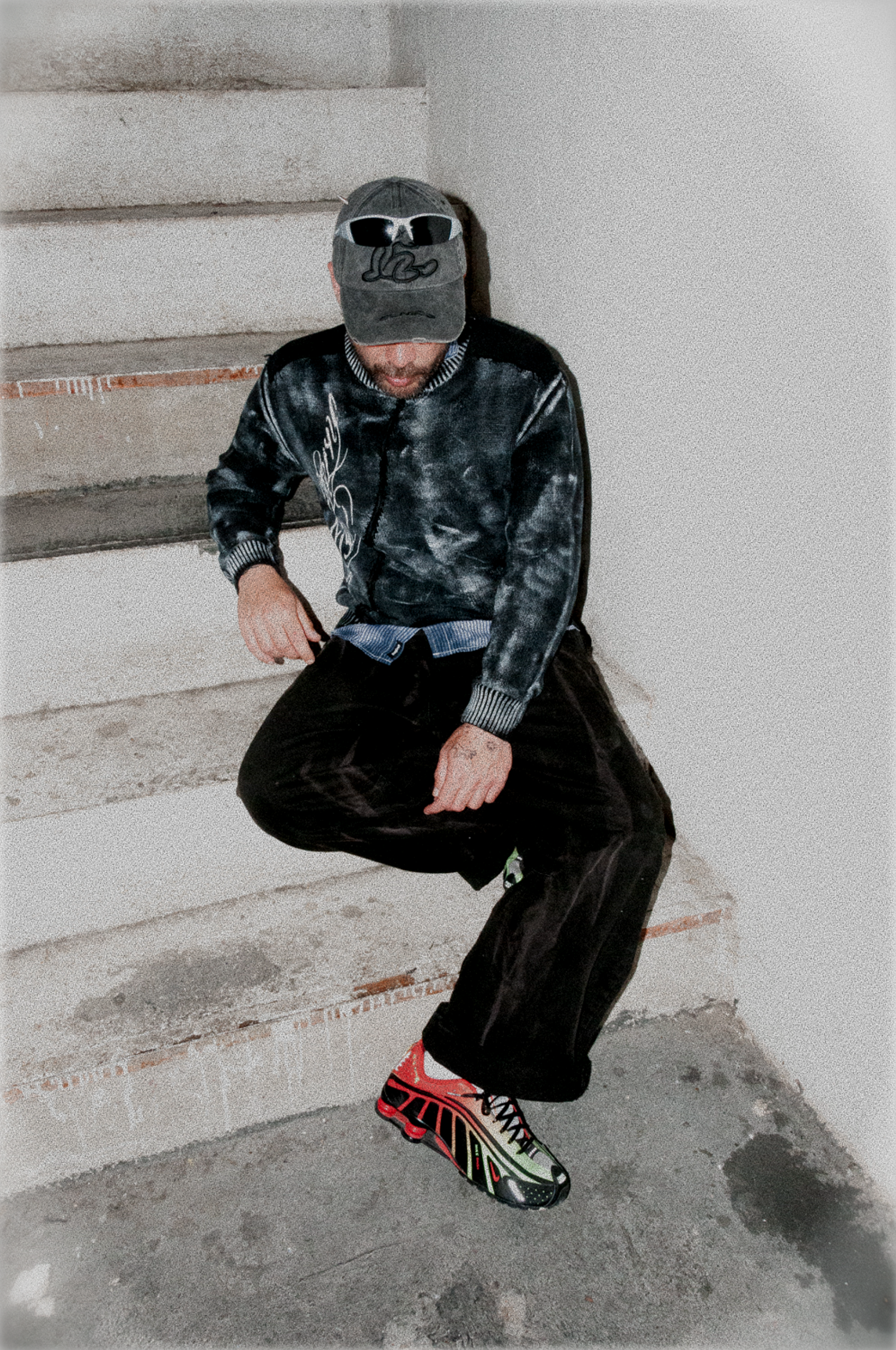 Bigotesucio sitting on a staircase