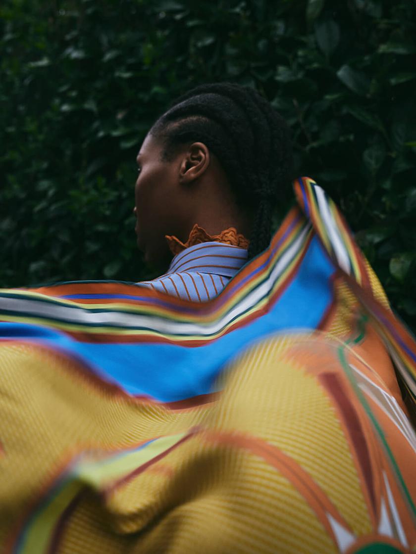 model holding scarf floating in the wind