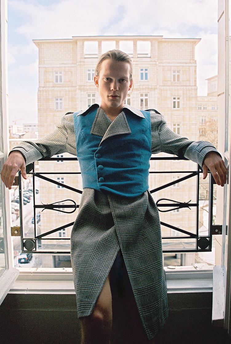 male model leans on window