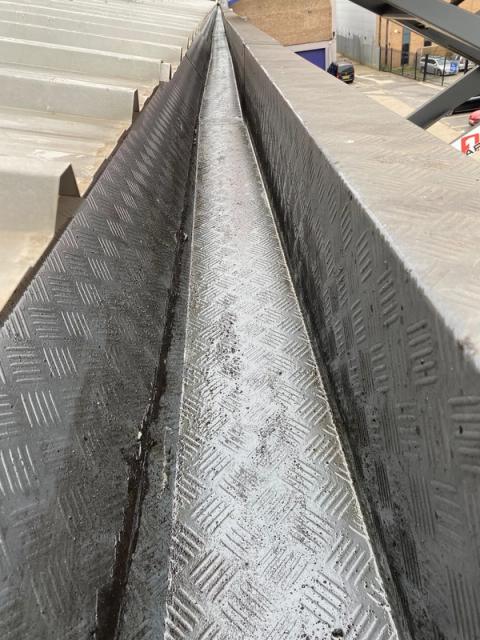 Commercial gutter after cleaning and waterproof coating application
