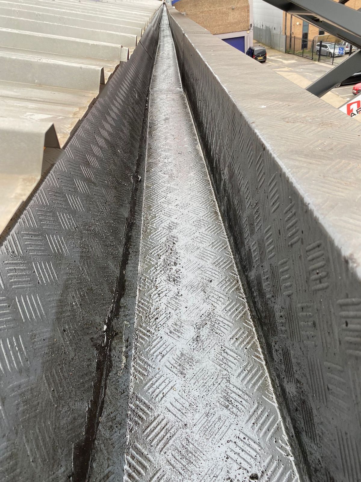 Commercial gutter after cleaning and waterproof coating application