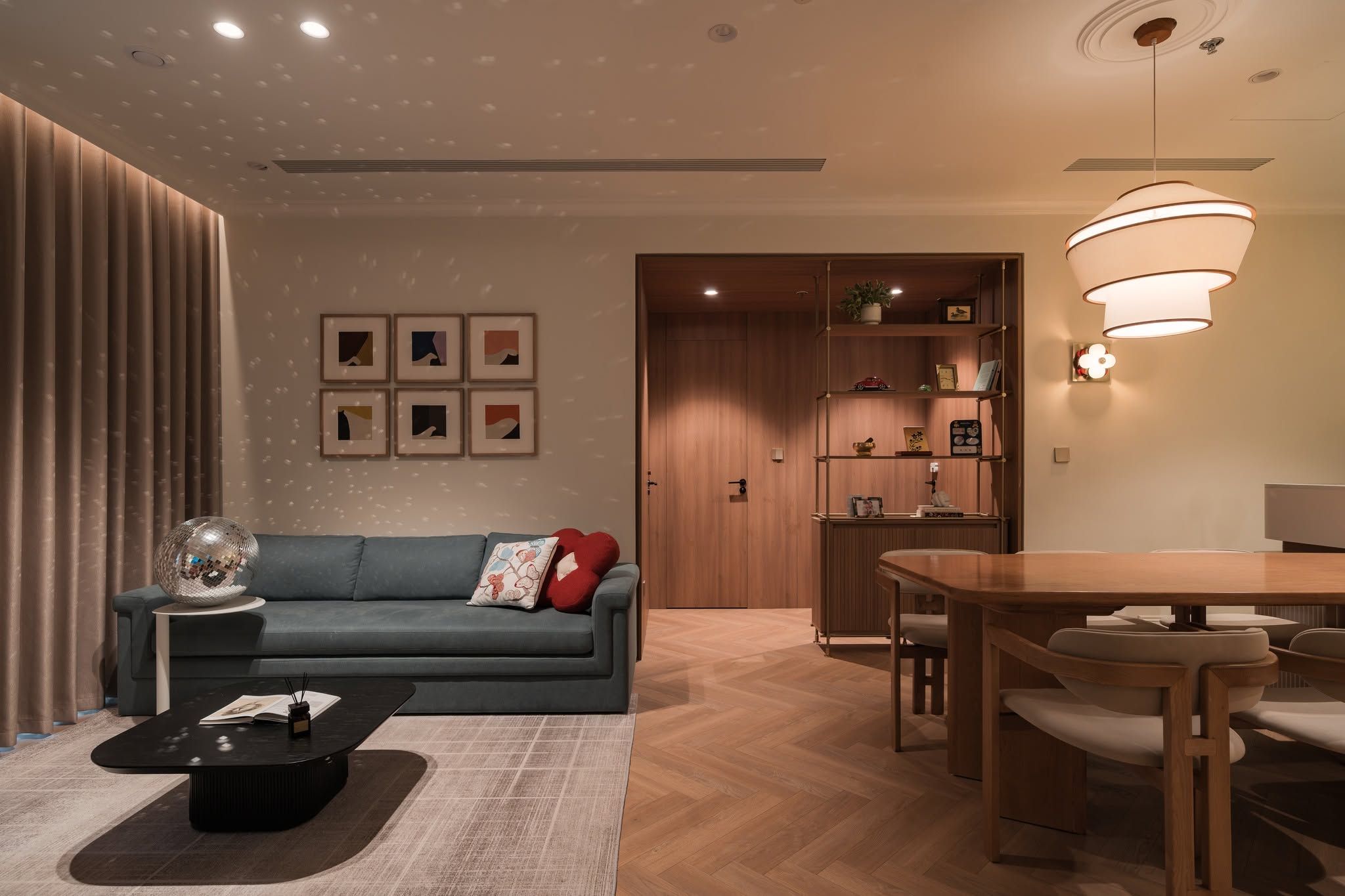 Living and dining room with herringbone oak floor and warm lighting
