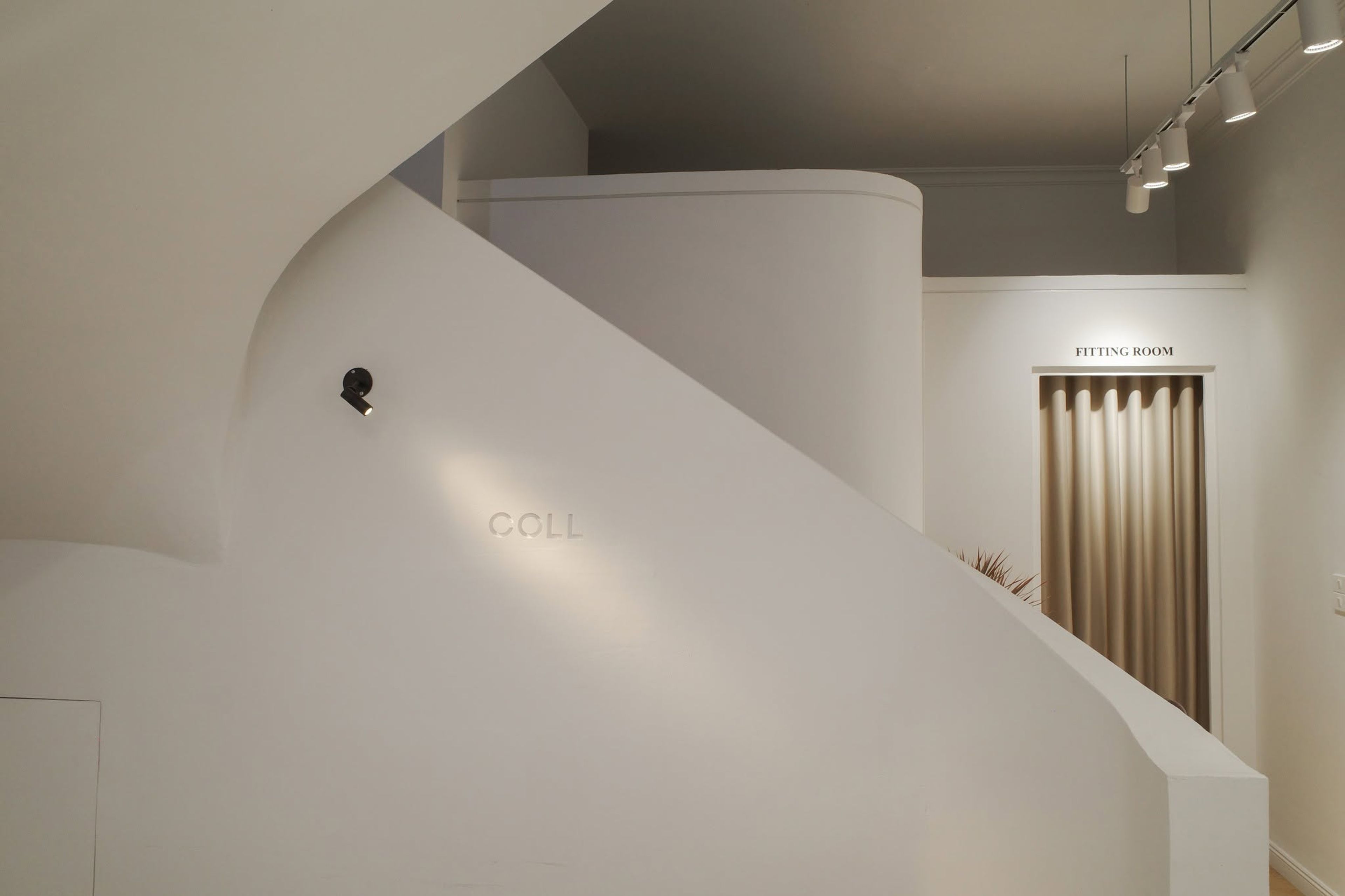 Curved white plaster stair with embossed Coll logo