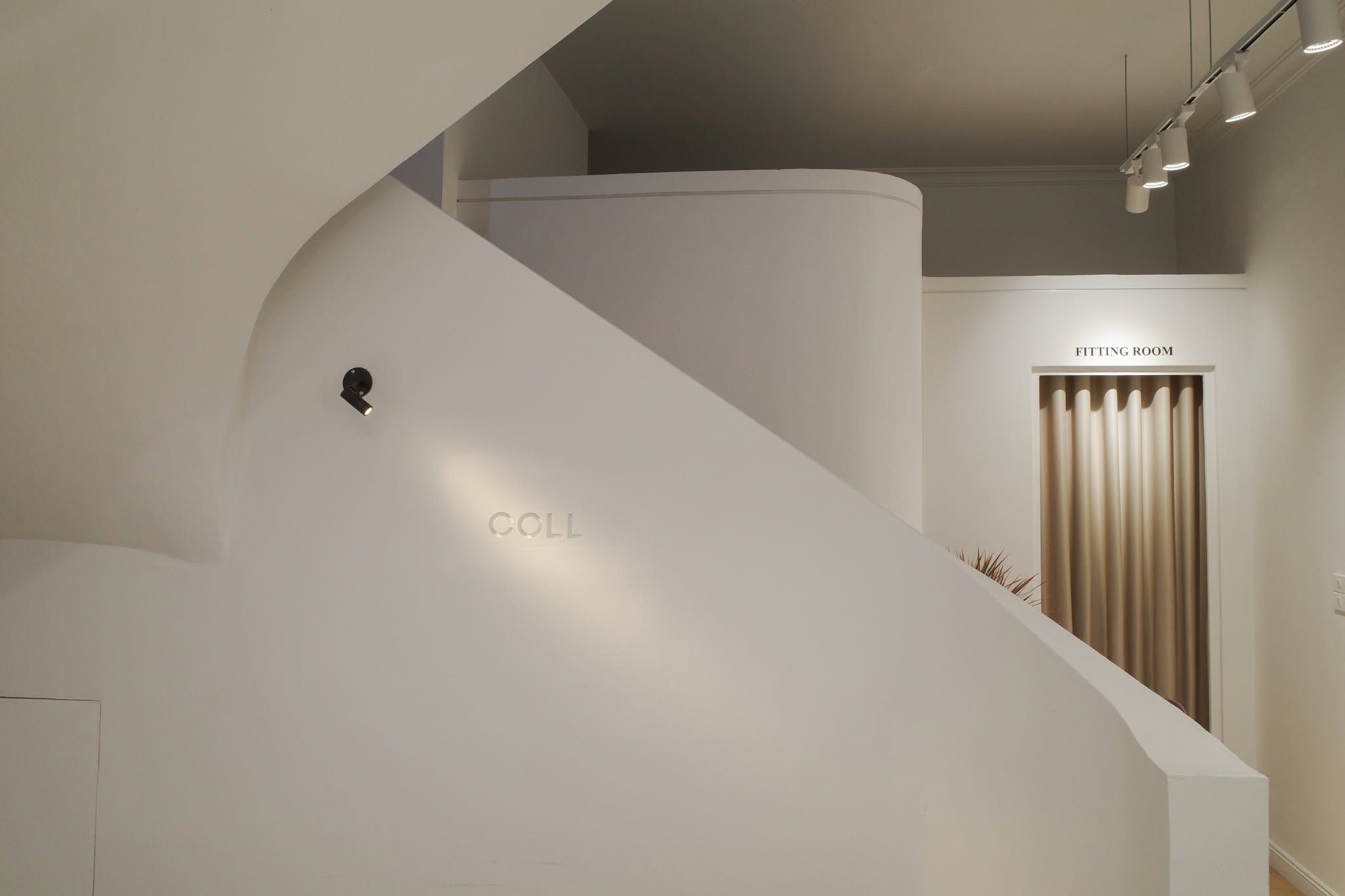 Curved white plaster stair with embossed Coll logo