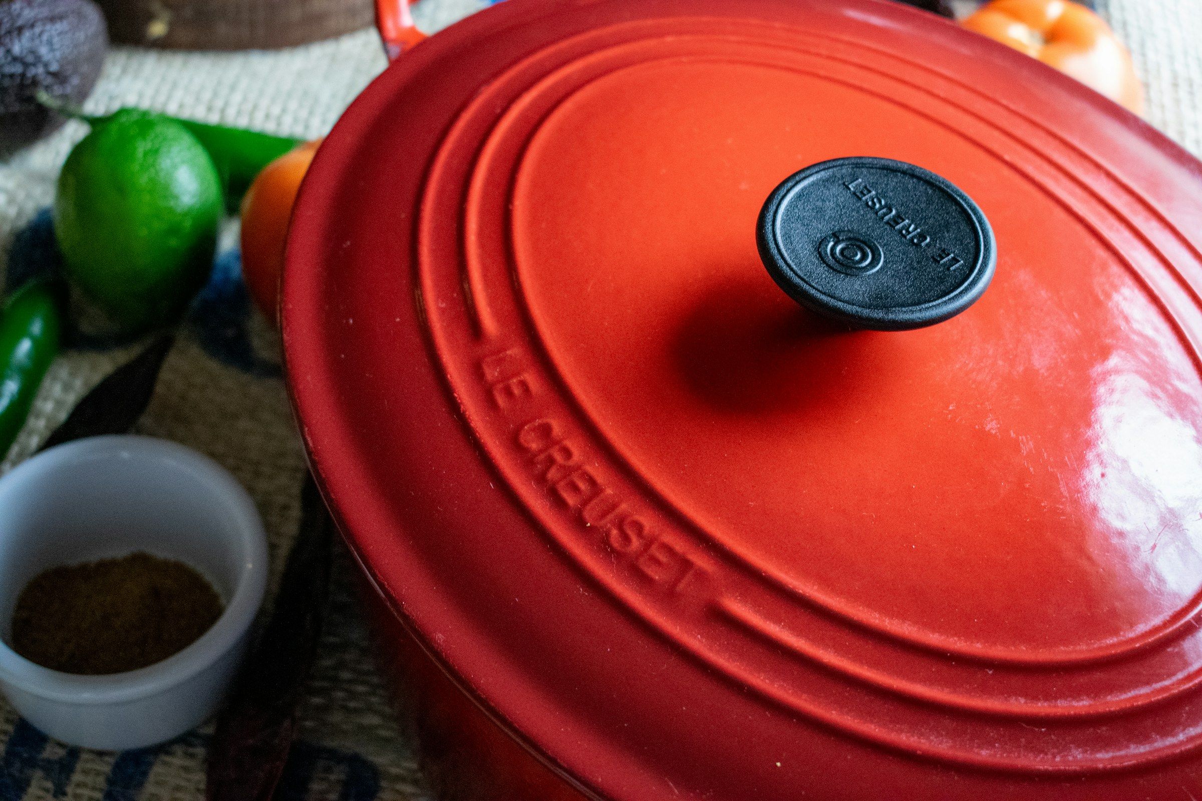 A red enameled cast iron Dutch oven on a kitchen table