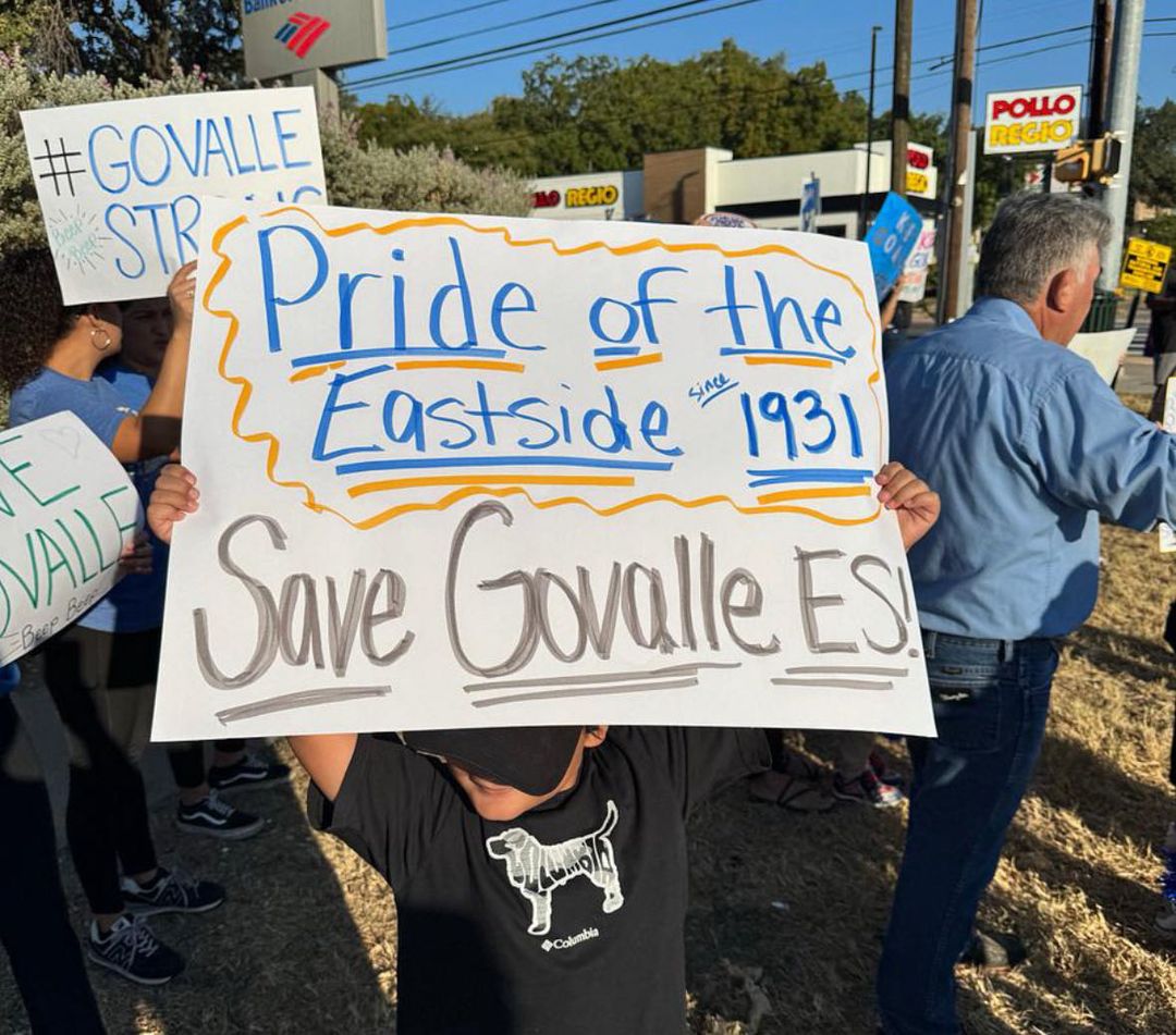 Students and parents outside holding protest signs