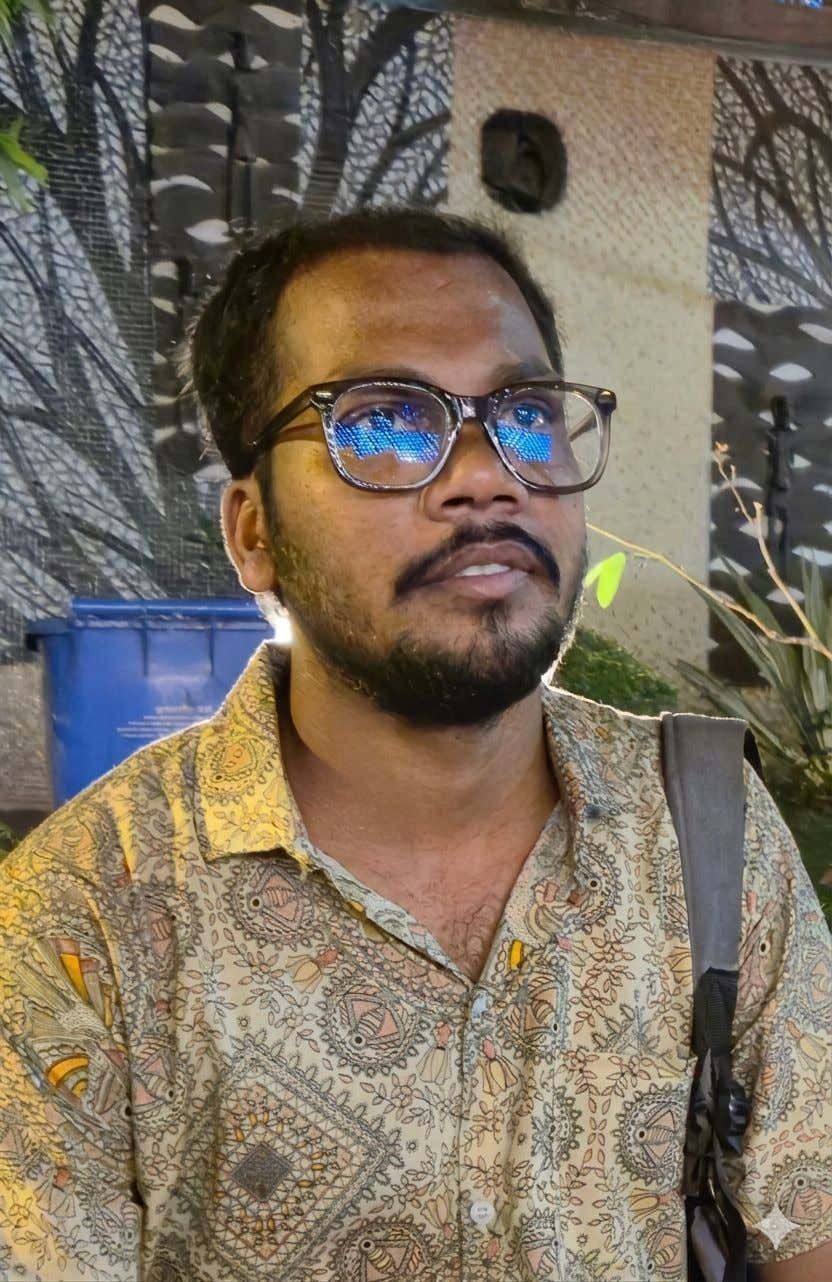 Portrait of Sovan Gorai outdoors, wearing glasses and a patterned shirt