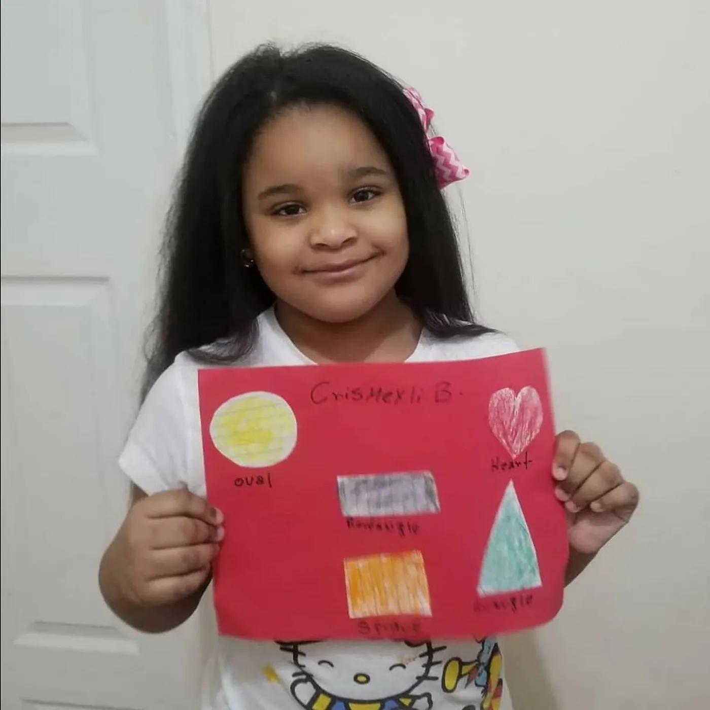 A student holding up a collage made in the Art & Shop Lab