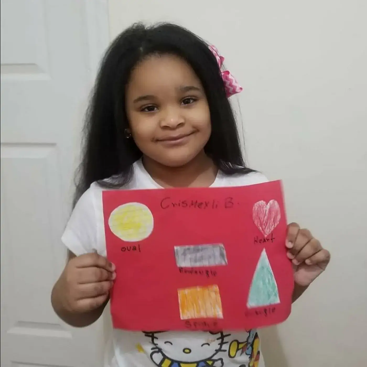 A student holding up a collage made in the Art & Shop Lab