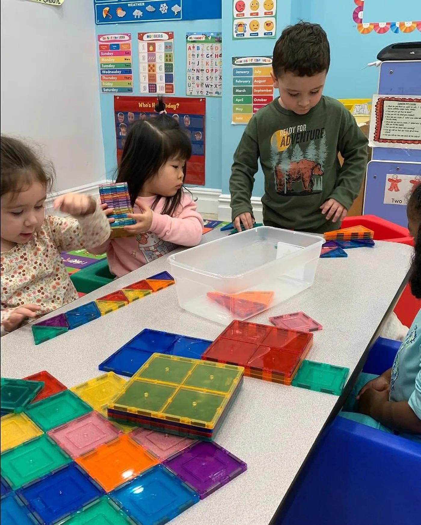 Young students building with coloured tiles at a classroom table