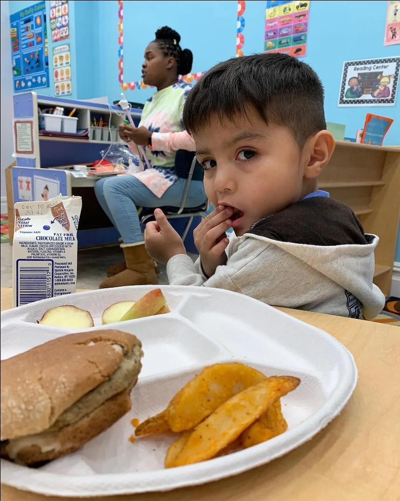 A student with a hot lunch tray in the cafeteria