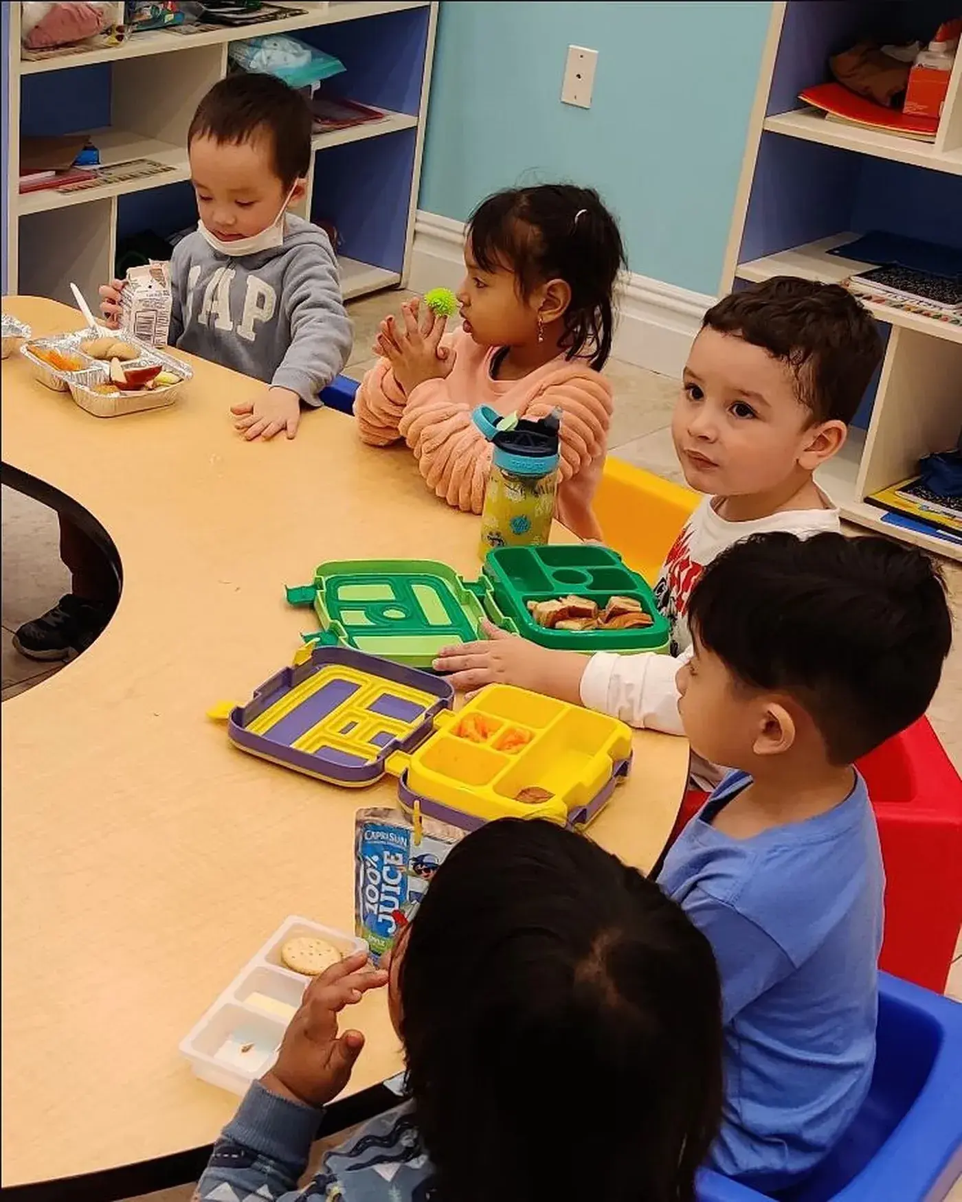 Young students building words with letter blocks at a table