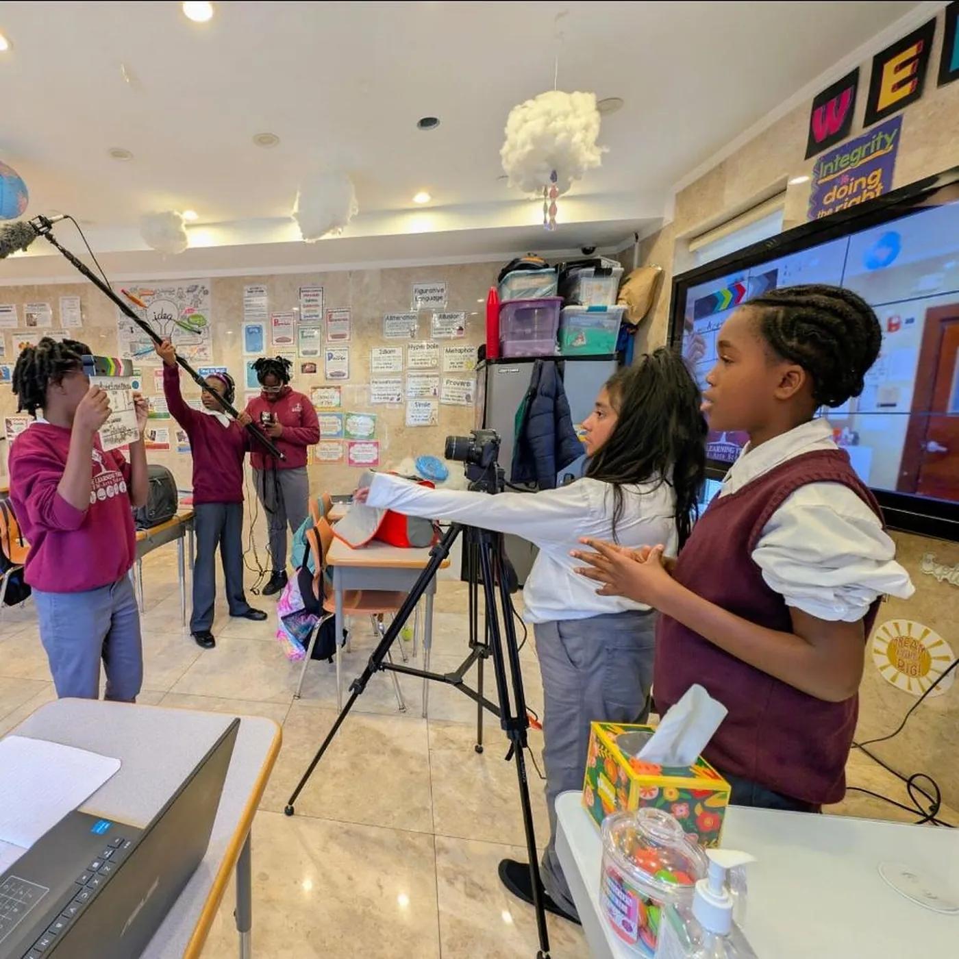 A student holding a boom microphone on a Media Arts Lab shoot