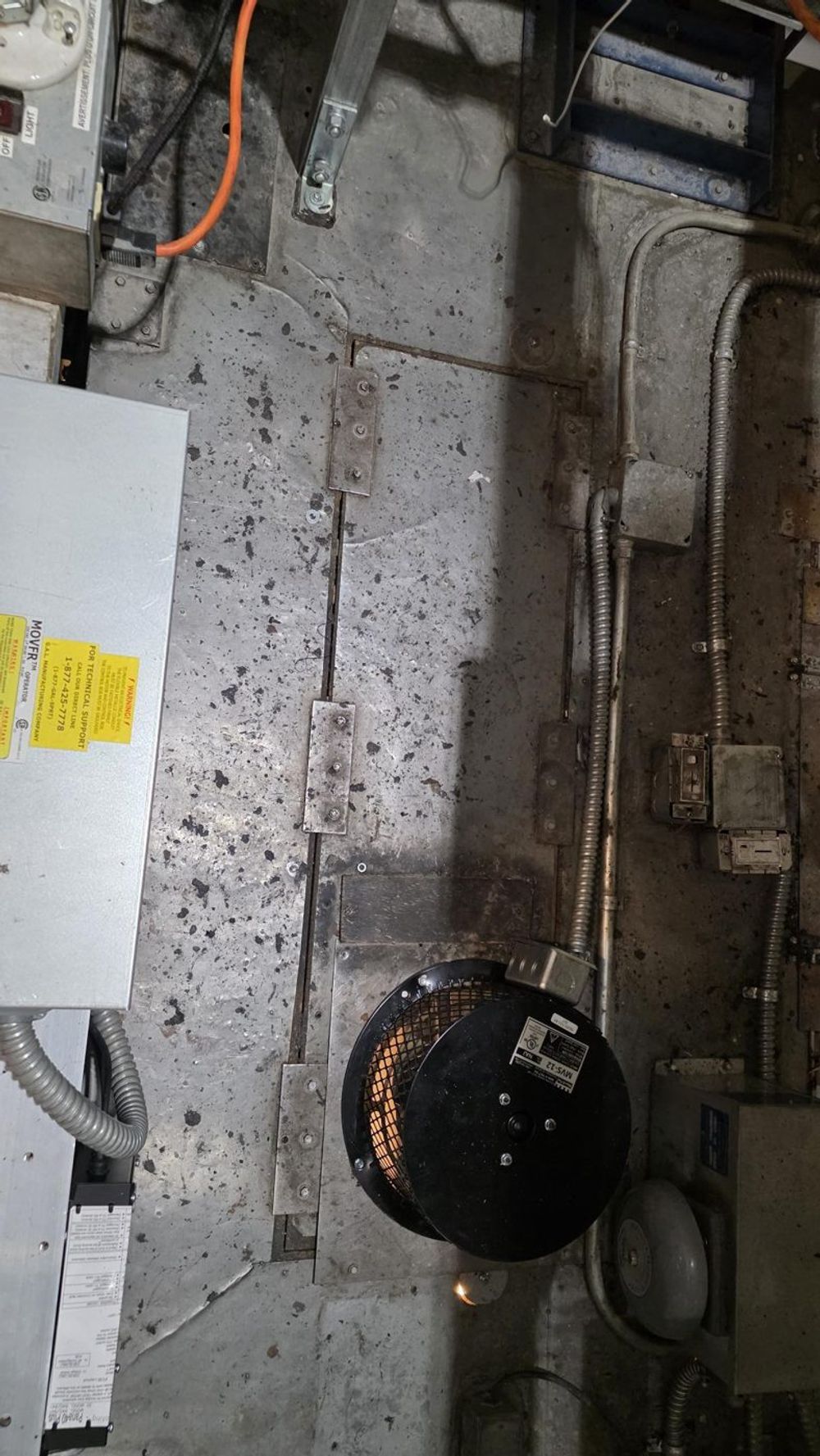 Top of an elevator car showing water-soaked, clumped dust after a water leak