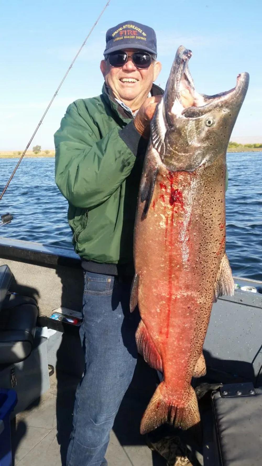 Angler holding a Chinook salmon aboard a Columbia River fishing boat