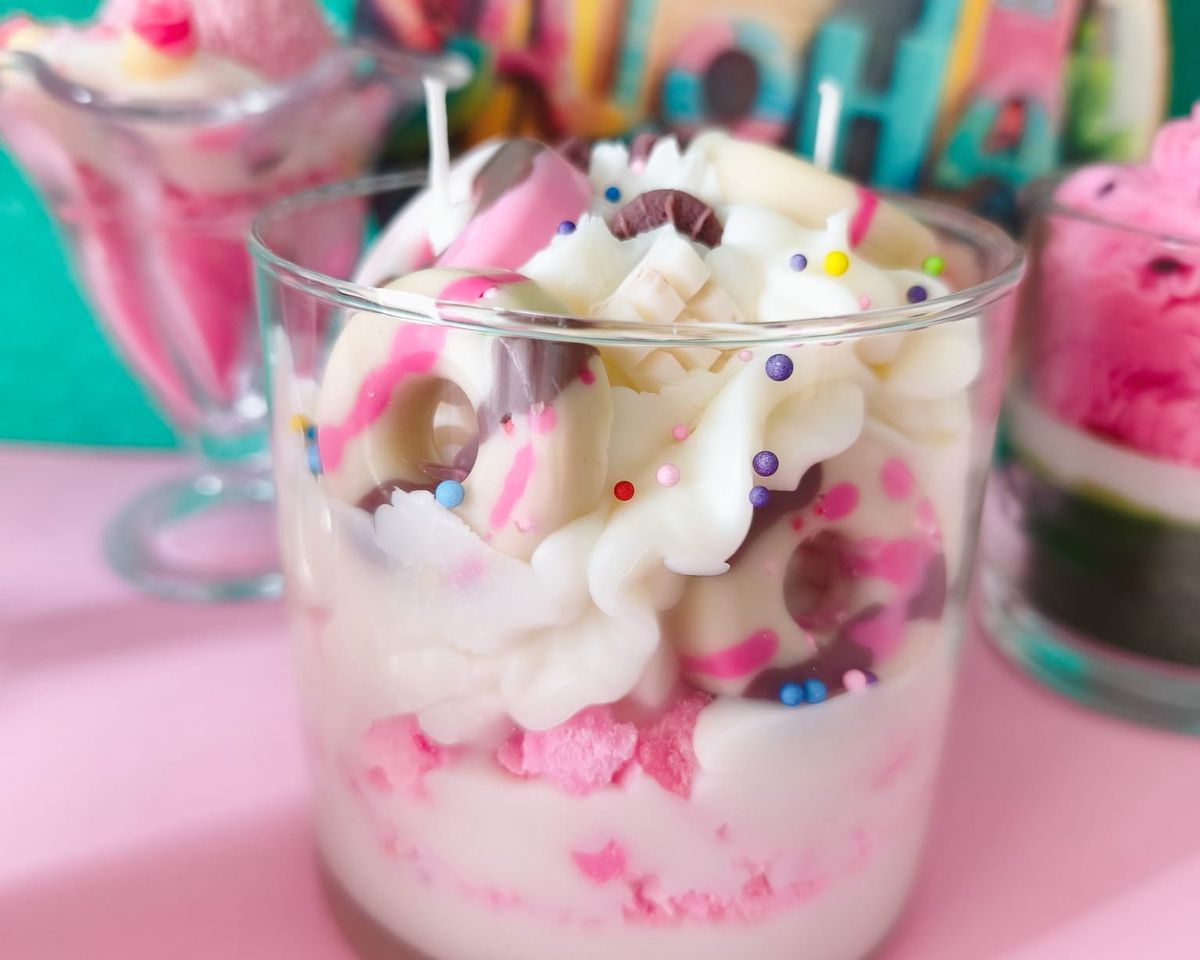 Nuestro tanque de cera - Crema montada con olor a chocolate blanco, galleta de color rosa con un toque a fresa y adornos de roscas y tabletas de chocolate con aroma a choco. En vaso de cristal.