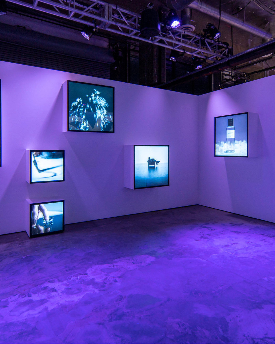 Digital screens displaying Gris Dior imagery on a wall at Dior’s Grey Zone exhibition in Los Angeles.