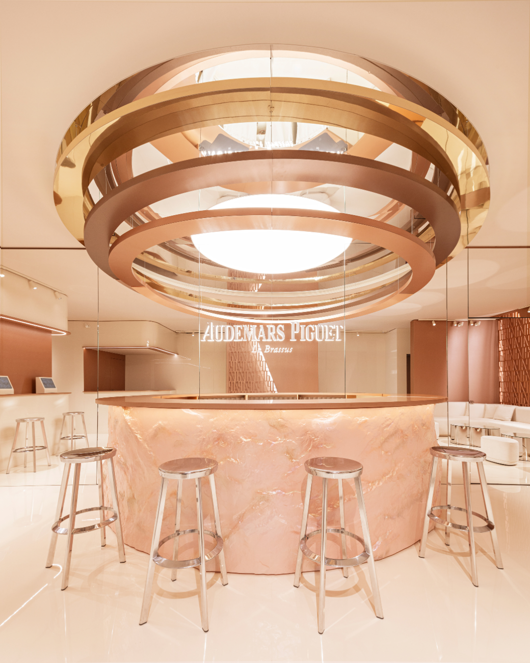 Marble bar desk and large ceiling light installation inside the bar room of Audemars Piguet Shaping Materials exhibition in Milan.