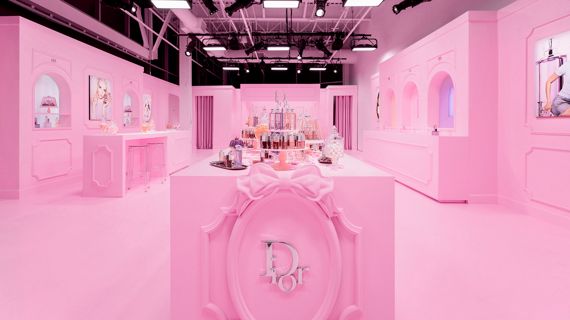 Pink buffet table with candy bottles and Dior products at the Dior Sweet pop-up in Los Angeles.