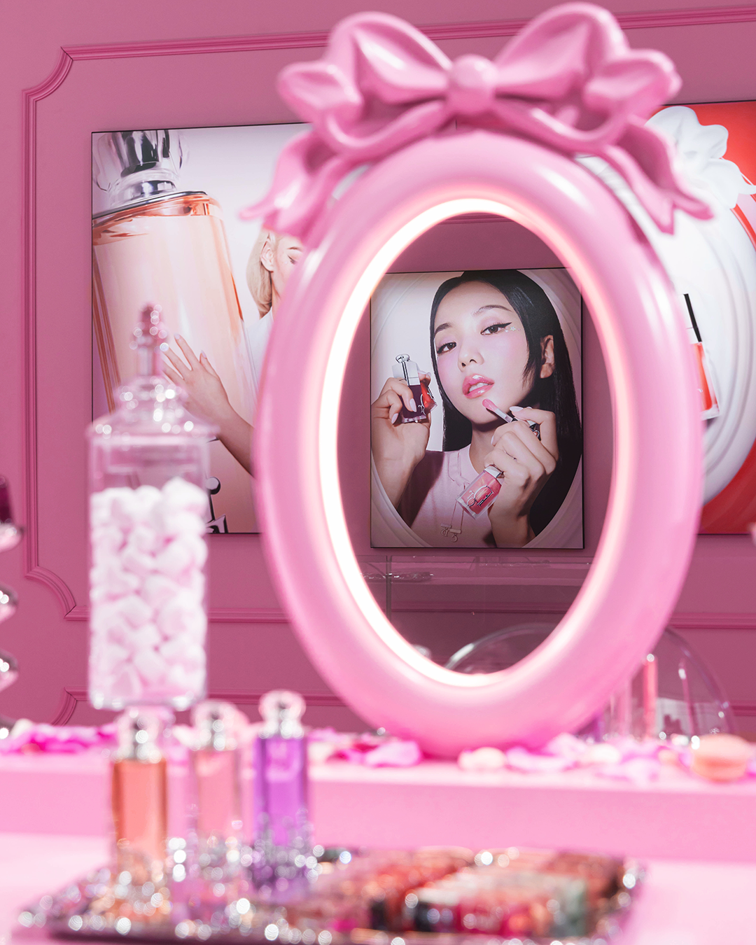Pink make-up station with candy bottles and Dior Beauty Lip Glow products at the Dior Sweet pop-up in Tokyo.
