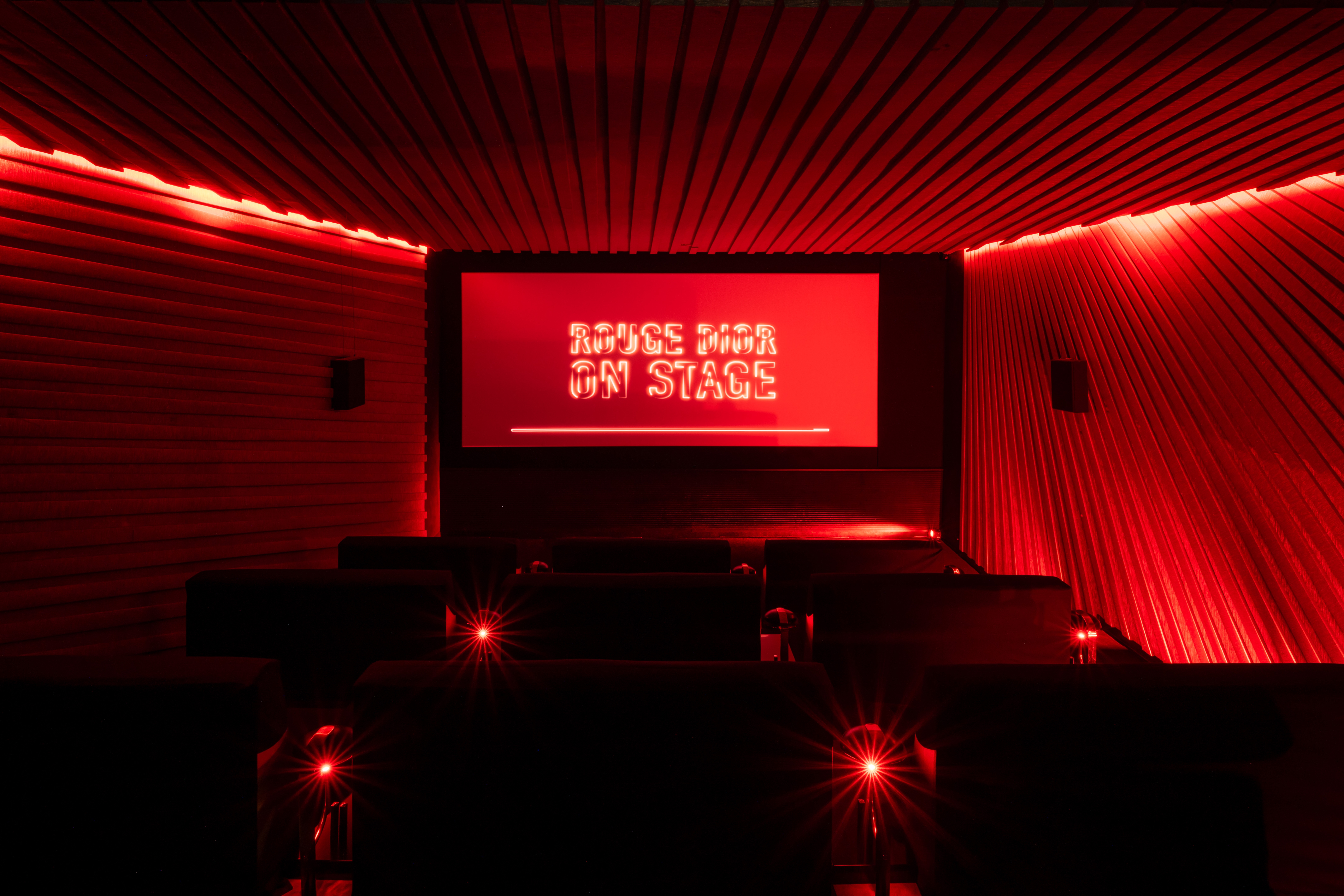 Red cinema room with Rouge Dior On Stage displayed on screen at Silencio Club in Paris.