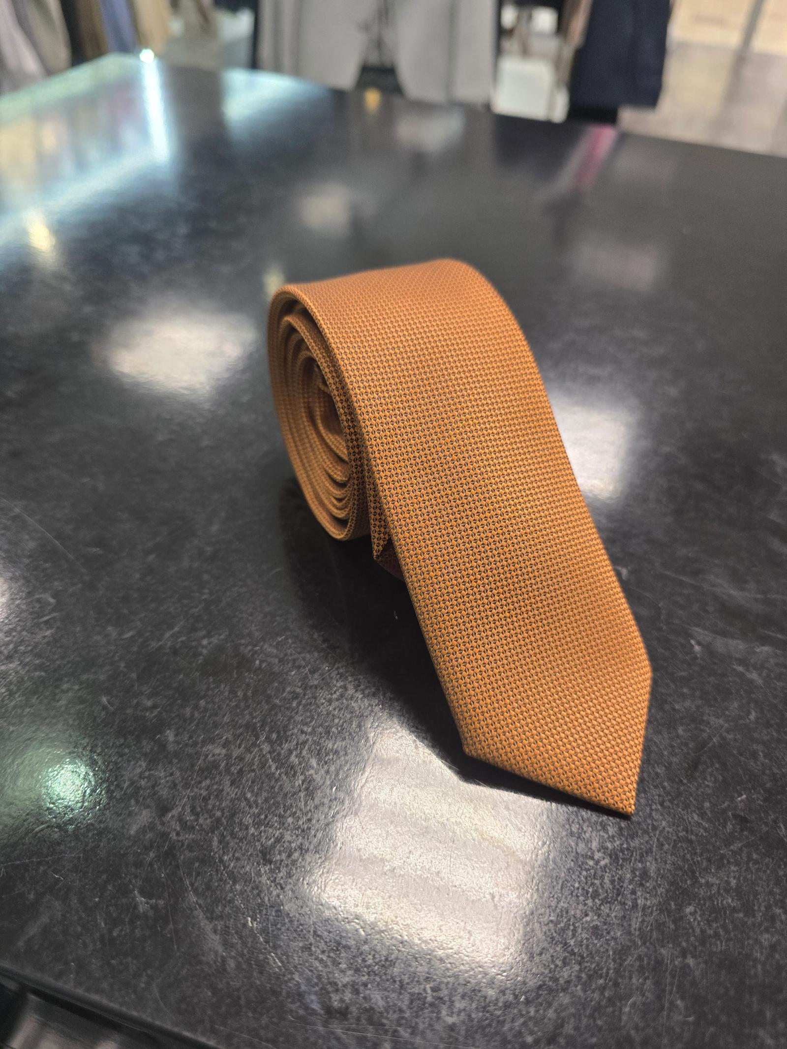 Viento textured burnt orange tie, vertical full-length view on dark counter