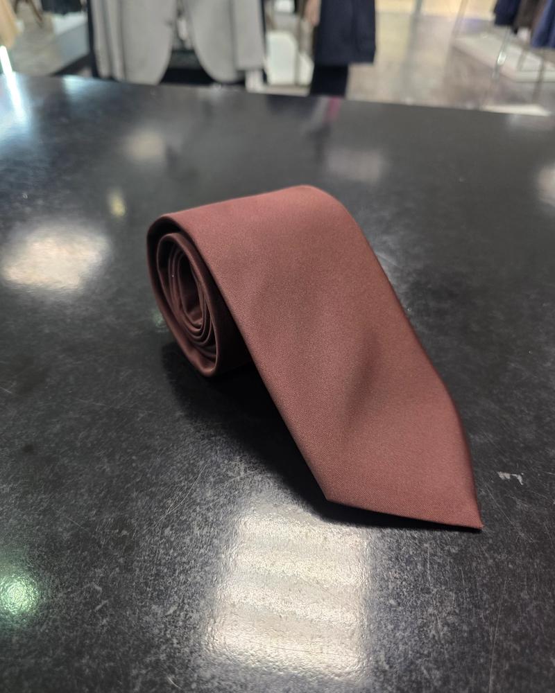 Viento burgundy satin tie, rolled view on dark counter