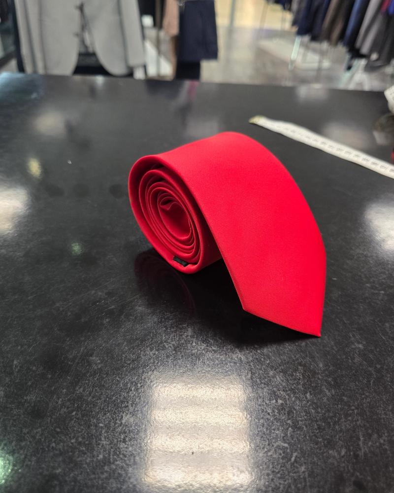 Viento red satin tie, rolled view on dark counter