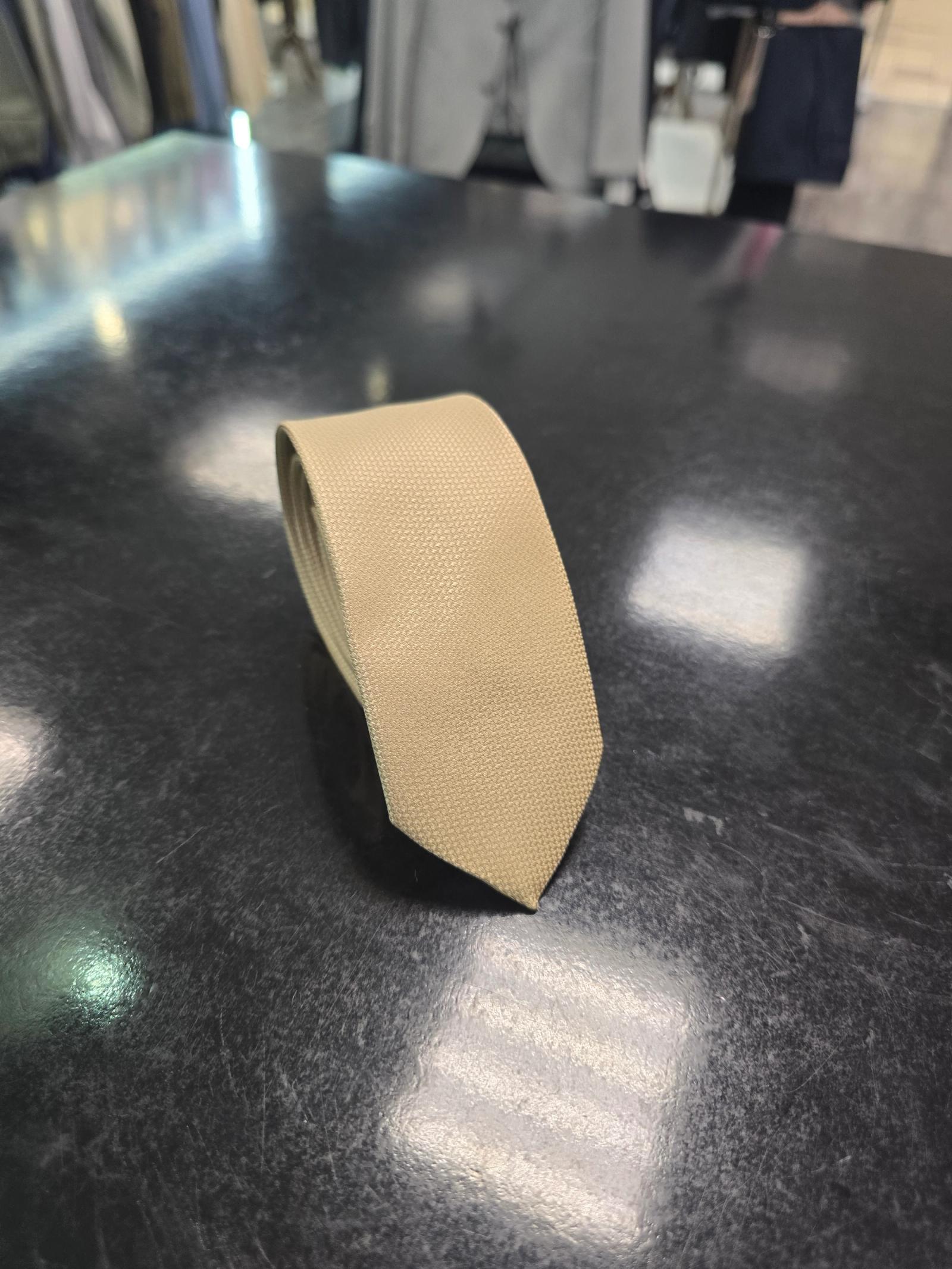 Viento beige tie, vertical full-length view on dark counter
