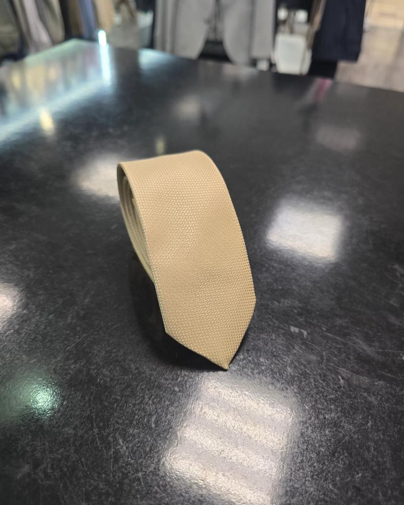 Viento beige tie, vertical full-length view on dark counter
