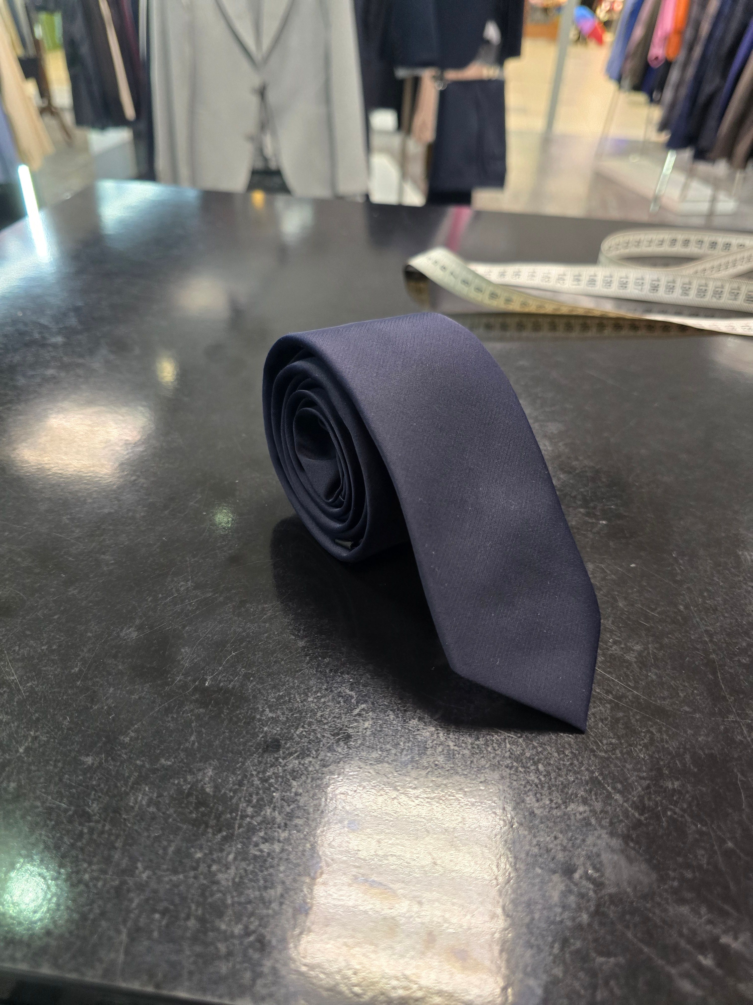 Viento slim navy tie, rolled view on dark counter